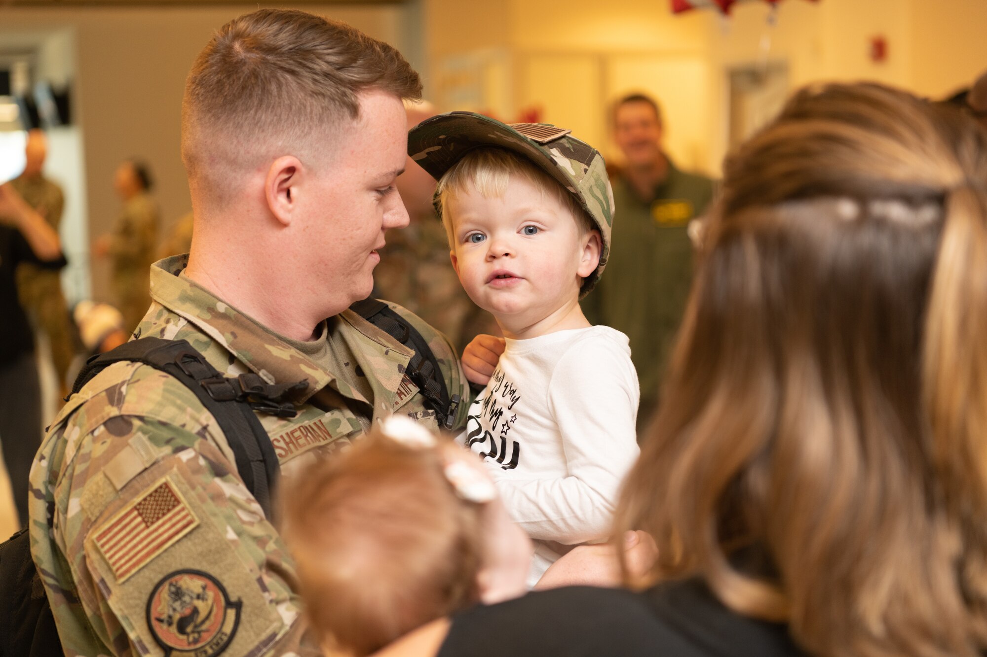 Airmen at an airport return from a deployment