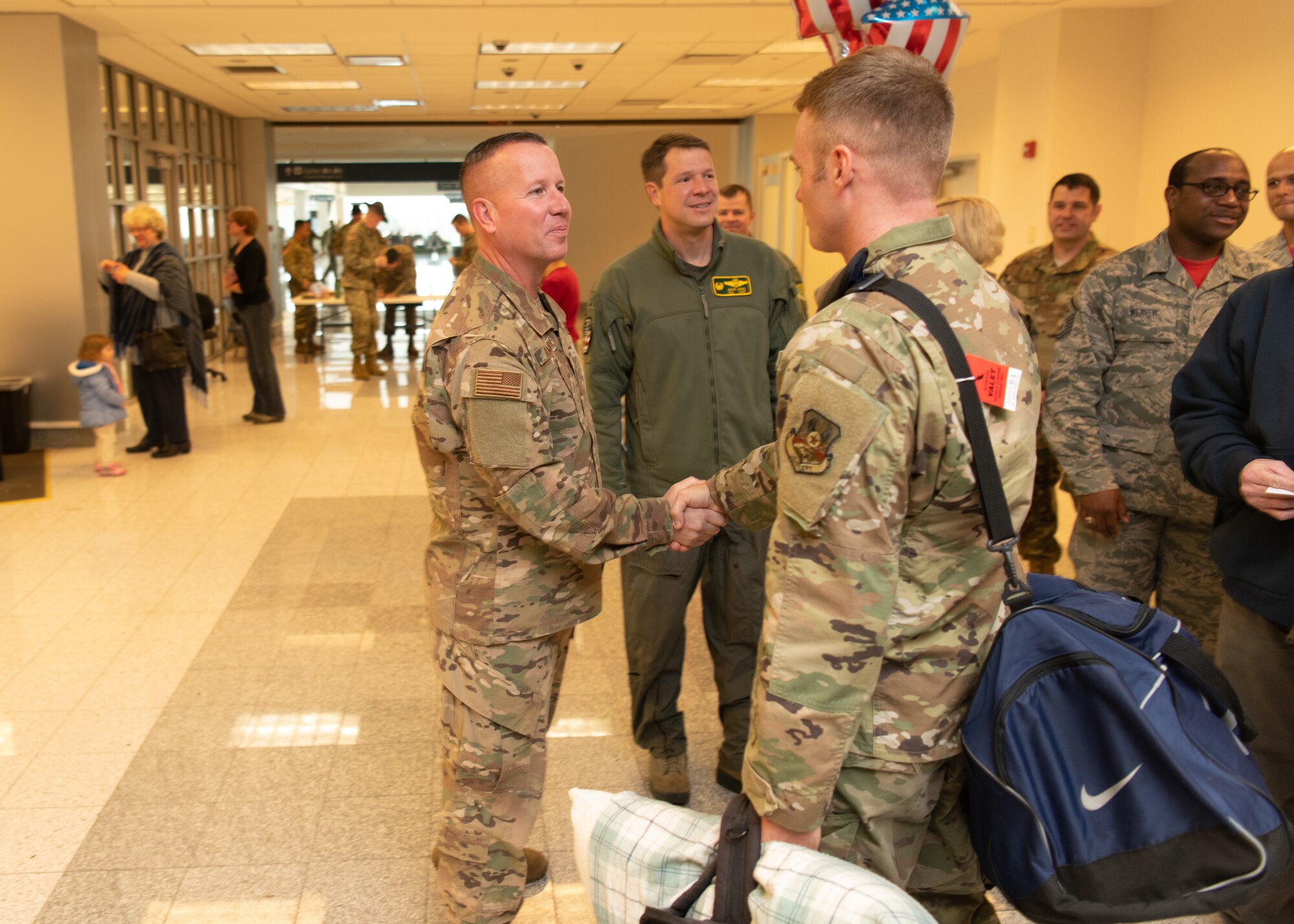 Airmen at an airport return from a deployment