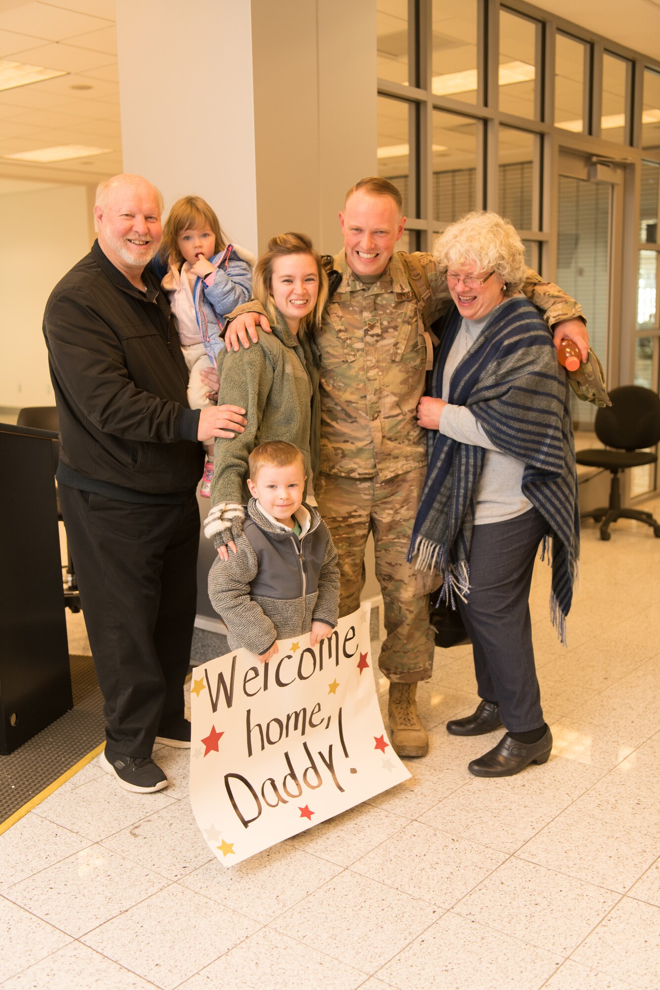 Airmen at an airport return from a deployment