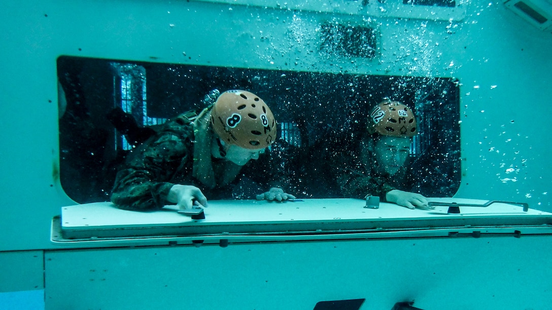 U.S. Marines escape from a simulated submerged Amphibious Assault Vehicle during a training event at the Submerged Vehicle Egress Trainer in the 53 Area pool on Marine Corps Base Camp Pendleton, California, Jan. 8.