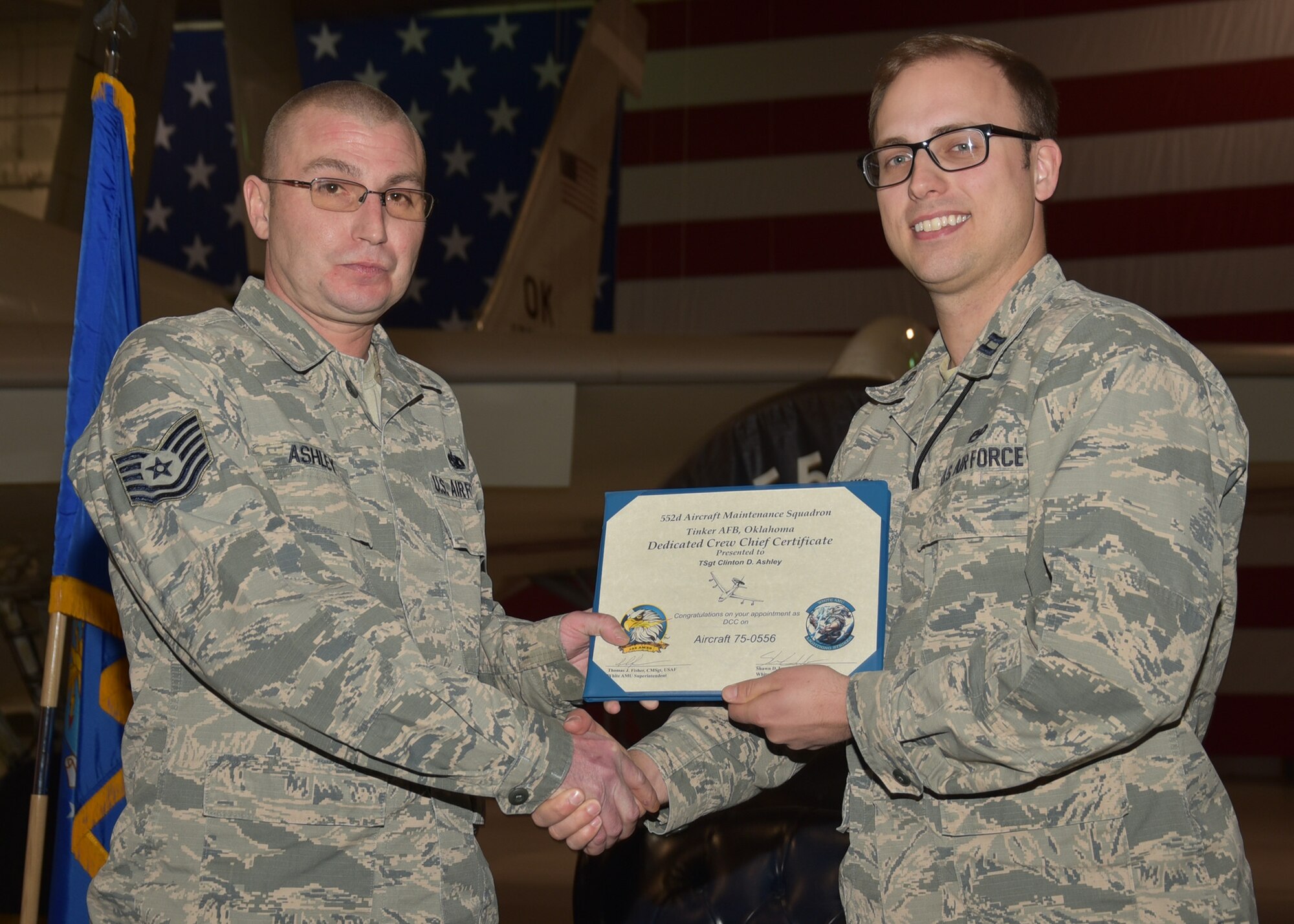 Capt. Shawn Lundskow, 552nd Maintenance Squadron/White Aircraft Maintenance Unit Officer in Charge, presents a dedicated crew chief certificate to Tech. Sgt. Clinton Ashley, 552nd MXS, during an E-3 Sentry aircraft dedication ceremony held Jan. 6, 2020 in Dock 2 of Bldg. 230. This marks the first time that the 966th Airborne Air Control Squadron had an E-3 Sentry aircraft dedicated for use by the squadron and will help forge a bond between aircrews and maintainers.

(Air Force photo/Ron Mullan)