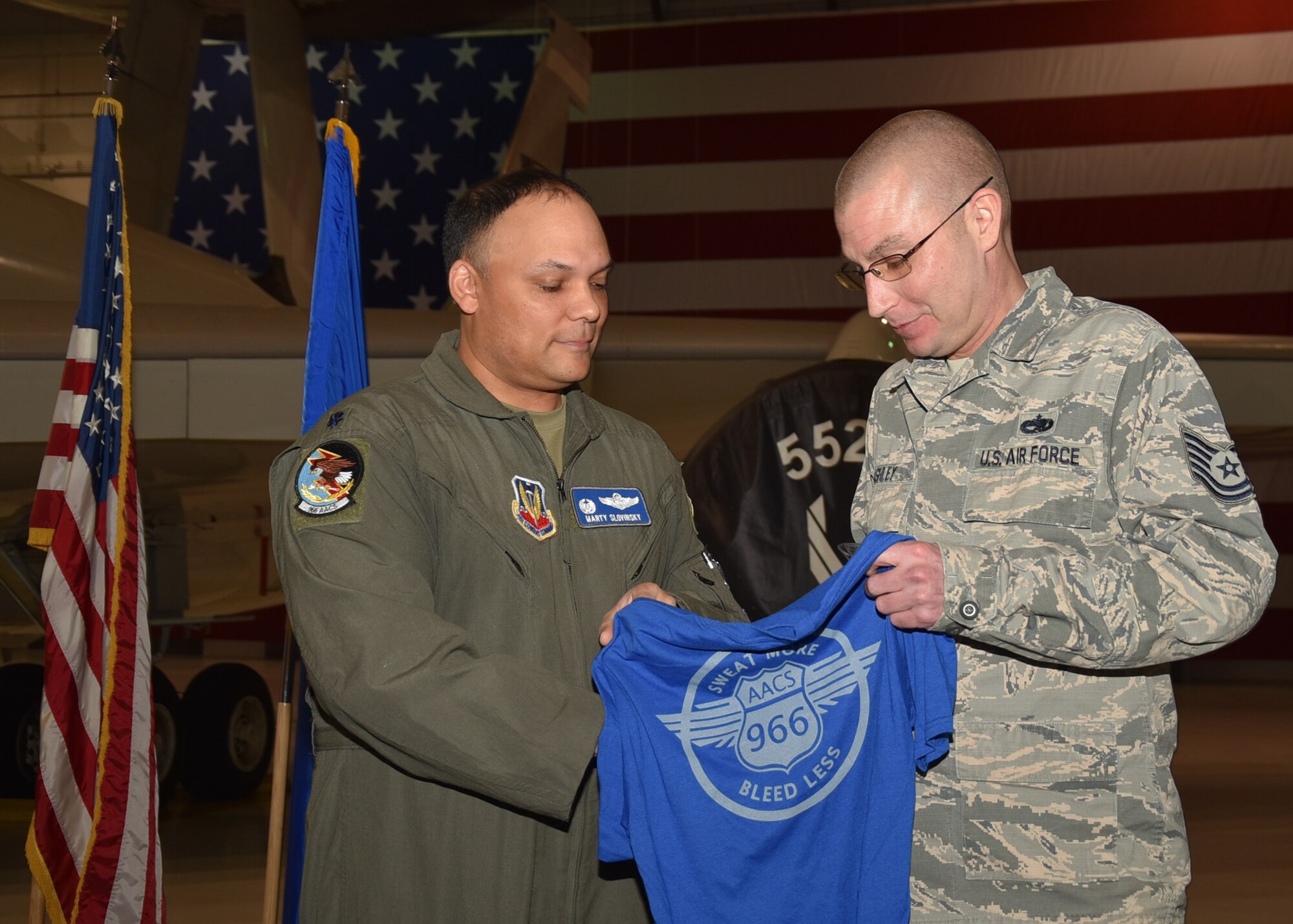 Lt. Col. Marty Slovinsky, 966th Airborne Air Control Squadron, Commander, presents a squadron morale T-shirt and commander’s coin to Tech. Sgt. Clinton Ashley, 552nd Maintenance Squadron during an E-3 Sentry aircraft dedication ceremony held Jan. 6, 2020 in Dock 2 of Bldg. 230. The ceremony marked the first time that an E-3 Sentry aircraft has been dedicated to the 966th AACS and will help forge a bond between aircrews and maintainers.

(Air Force photo/Ron Mullan