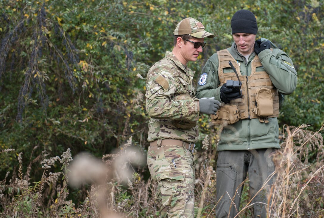 U.S. Air Force Tech. Sgt. Stephen Drakes, 192 Operations Support Squadron, Virginia Air National Guard SERE Survival, Evasion, Resistance and Escape non-commissioned officer in charge, watches as Capt. Nathan Miller, 94th Fighter Squadron instructor pilot, demonstrates how to work a survival radio during a training at Joint Base Langley-Eustis, Virginia, Dec. 12, 2019. Participants used the equipment they would have in an isolation situation. (U.S. Air Force photo by Airman 1st Class Sarah Dowe)