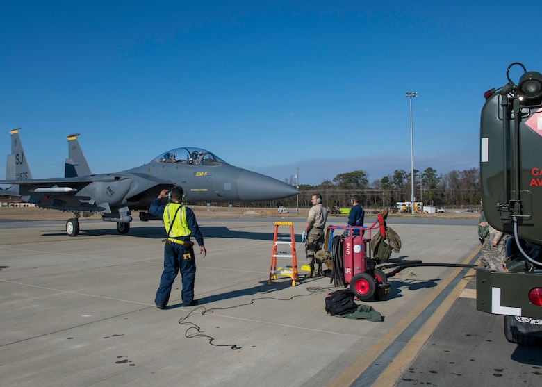 Airmen from the 4th Logistics Readiness Squadron marshal an F-15E Strike Eagle to an R-11 fuel truck for hot-pit refueling.