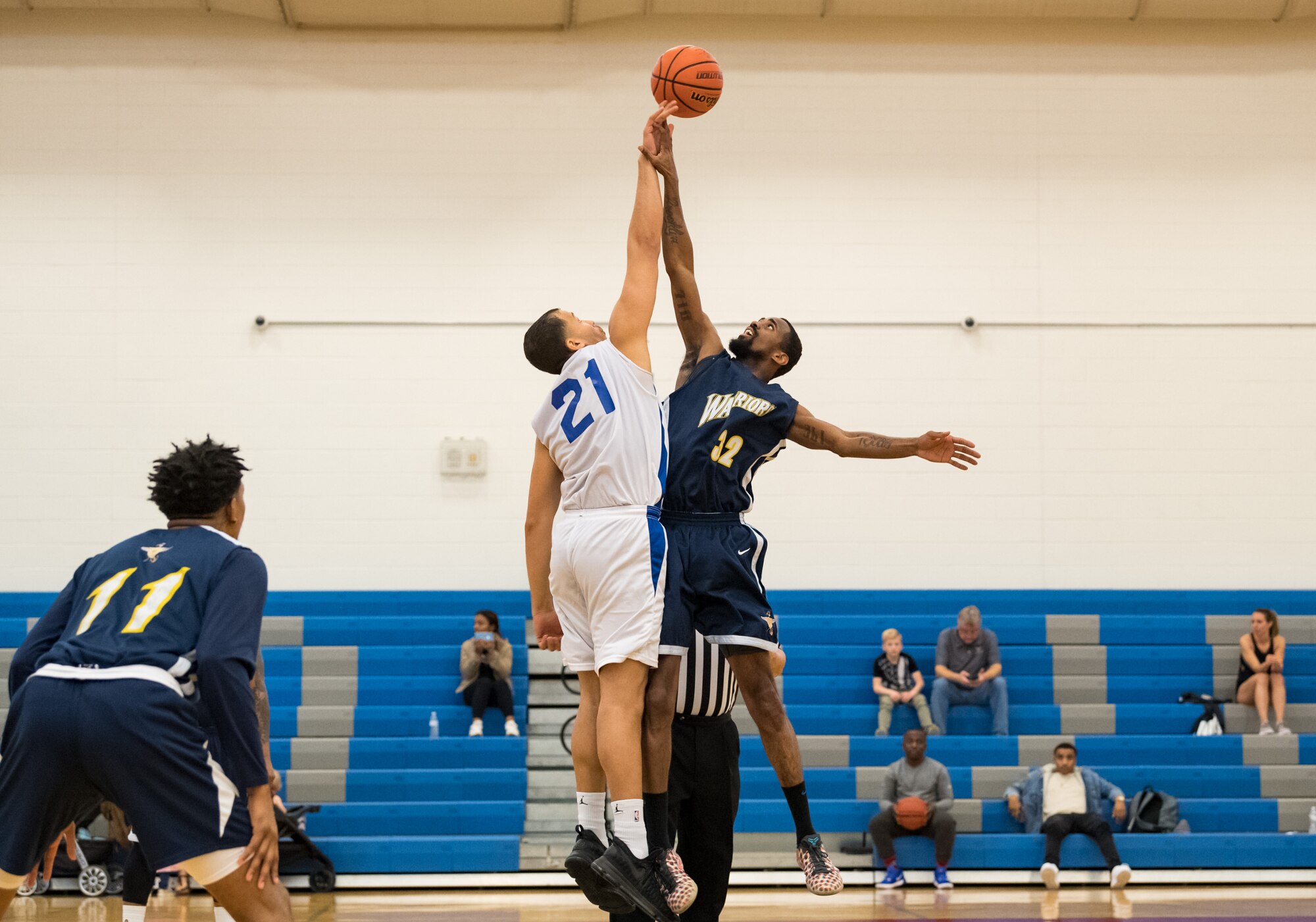 Dover Air Force Base Eagles center Miguel Garcia (21) and Naval Support Activity Bethesda Warriors center Charles Lewis (32) jump for the ball at the tipoff of their Washington Area Military Athletic Conference basketball game Jan. 12, 2020, at the Fitness Center on Dover AFB, Del. The Warriors topped the Eagles, 88-70. (U.S. Air Force photo by Roland Balik)