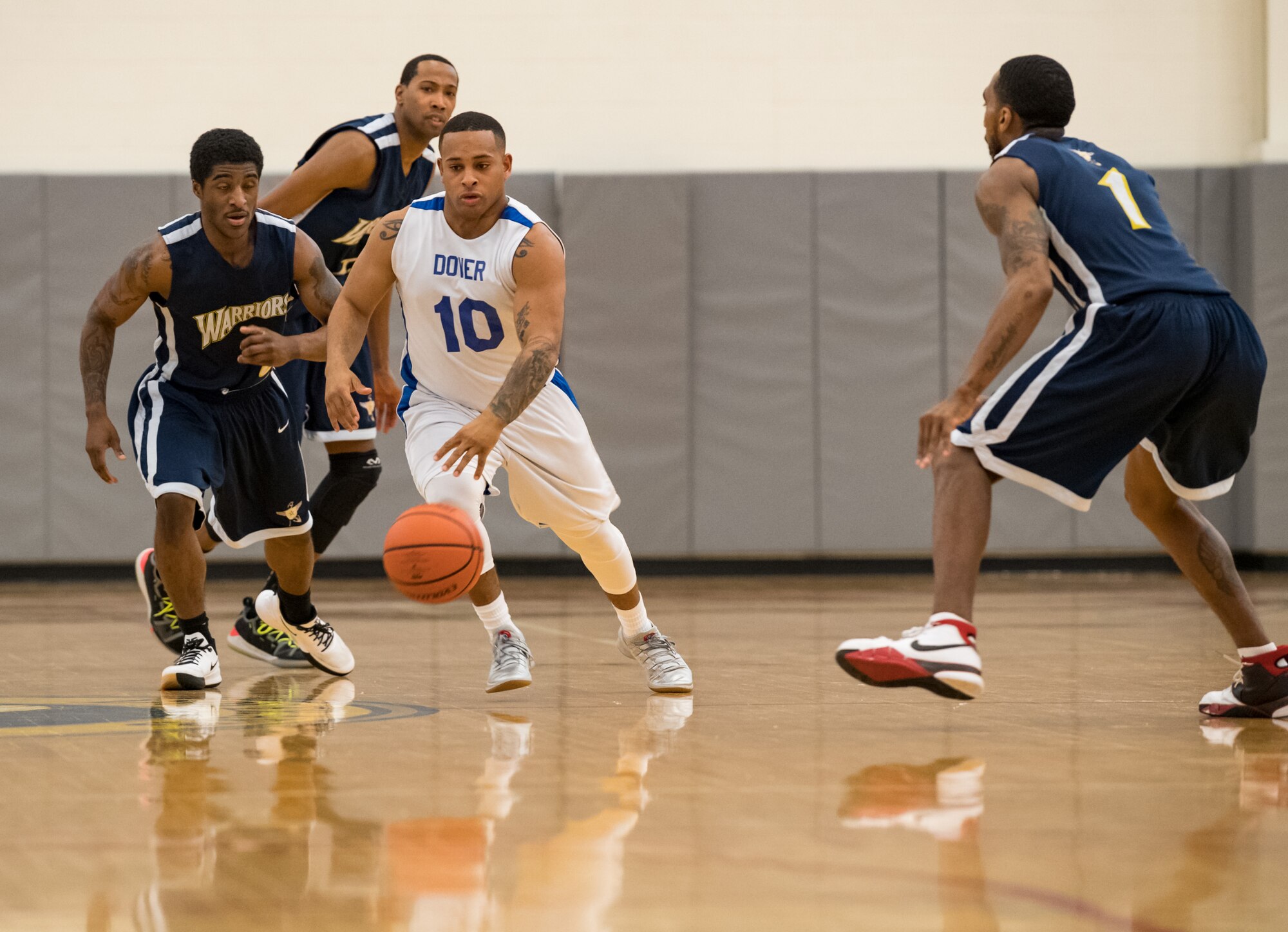 Dover Air Force Base Eagles guard Artis Mitchell (10) dribbles between Matthew Evans and Ryan Coleman (1), guards for the Naval Support Activity Bethesda Warriors, during the Washington Area Military Athletic Conference game Jan. 12, 2020, at the Fitness Center on Dover Air Force Base, Del. The Warriors topped the Eagles, 88-70. (U.S. Air Force photo by Roland Balik)