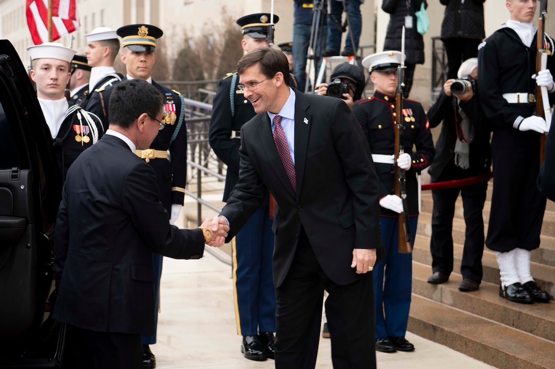 Defense Secretary Dr. Mark T. Esper shakes hands with another civilian outside the Pentagon.