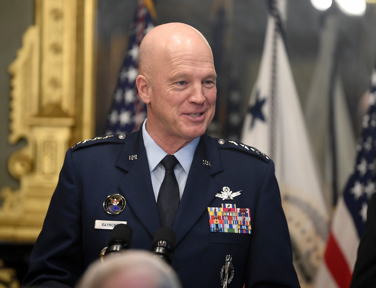 A person in uniform speaks at a podium.