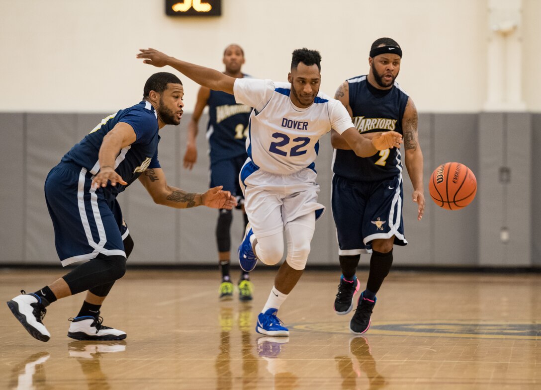 Dover Air Force Base Eagles guard Marcus Ward (22) goes between Demetris Johnson and Jabari Dumas (2), guards for the Naval Support Activity Bethesda Warriors, during the Washington Area Military Athletic Conference basketball game Jan. 12, 2020, at the Fitness Center on Dover Air Force Base, Del. The Warriors topped the Eagles, 88-70. (U.S. Air Force photo by Roland Balik)