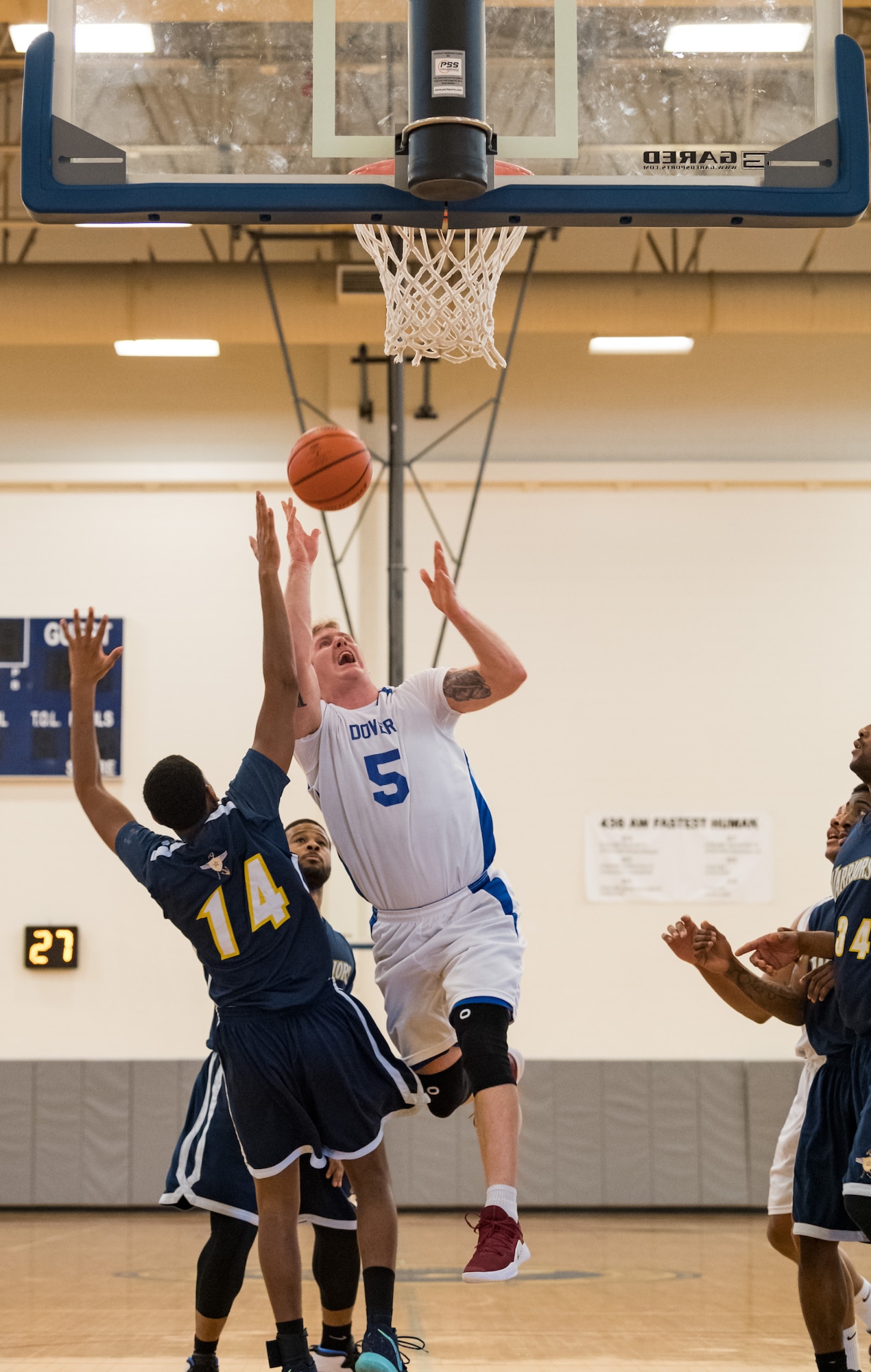 Dover Air Force Base Eagles center Ian McVay (5) goes for a layup over Naval Support Activity Bethesda Warriors forward Deshawn Keys (14) during the Washington Area Military Athletic Conference basketball game Jan. 12, 2020, at the Fitness Center on Dover Air Force Base, Del. The Warriors topped the Eagles, 88-70. (U.S. Air Force photo by Roland Balik)