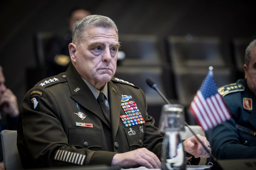 A military officer sits at a table.