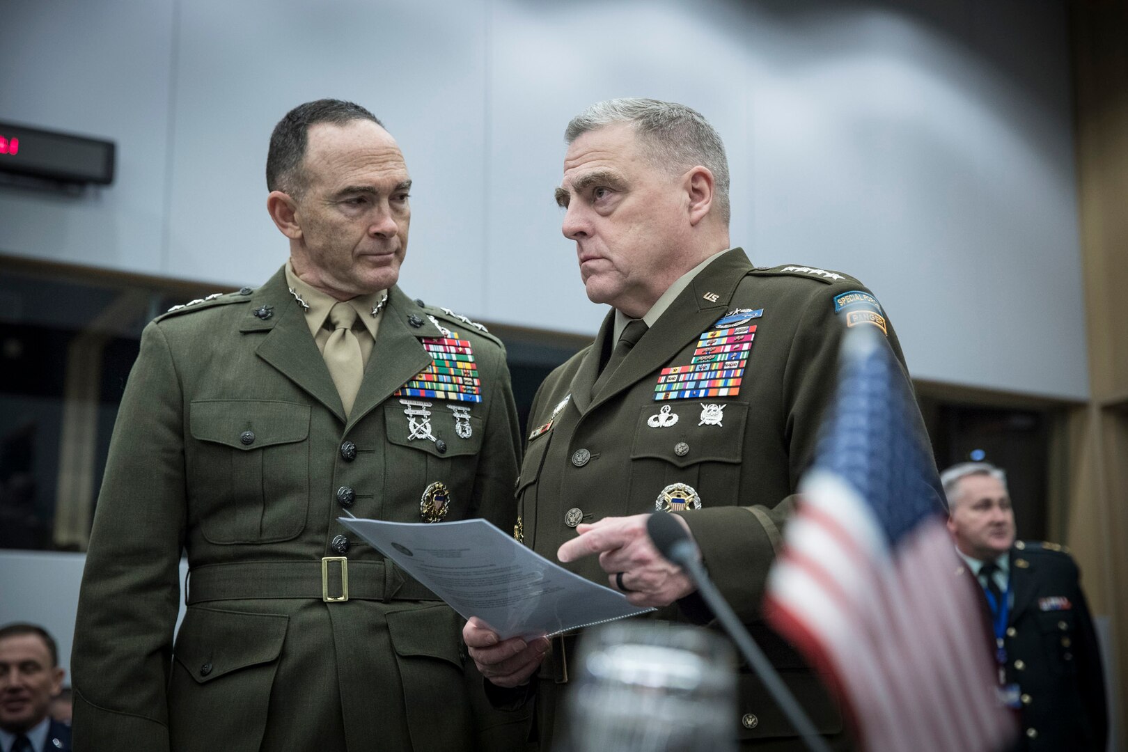 Two military officers speak to each other.