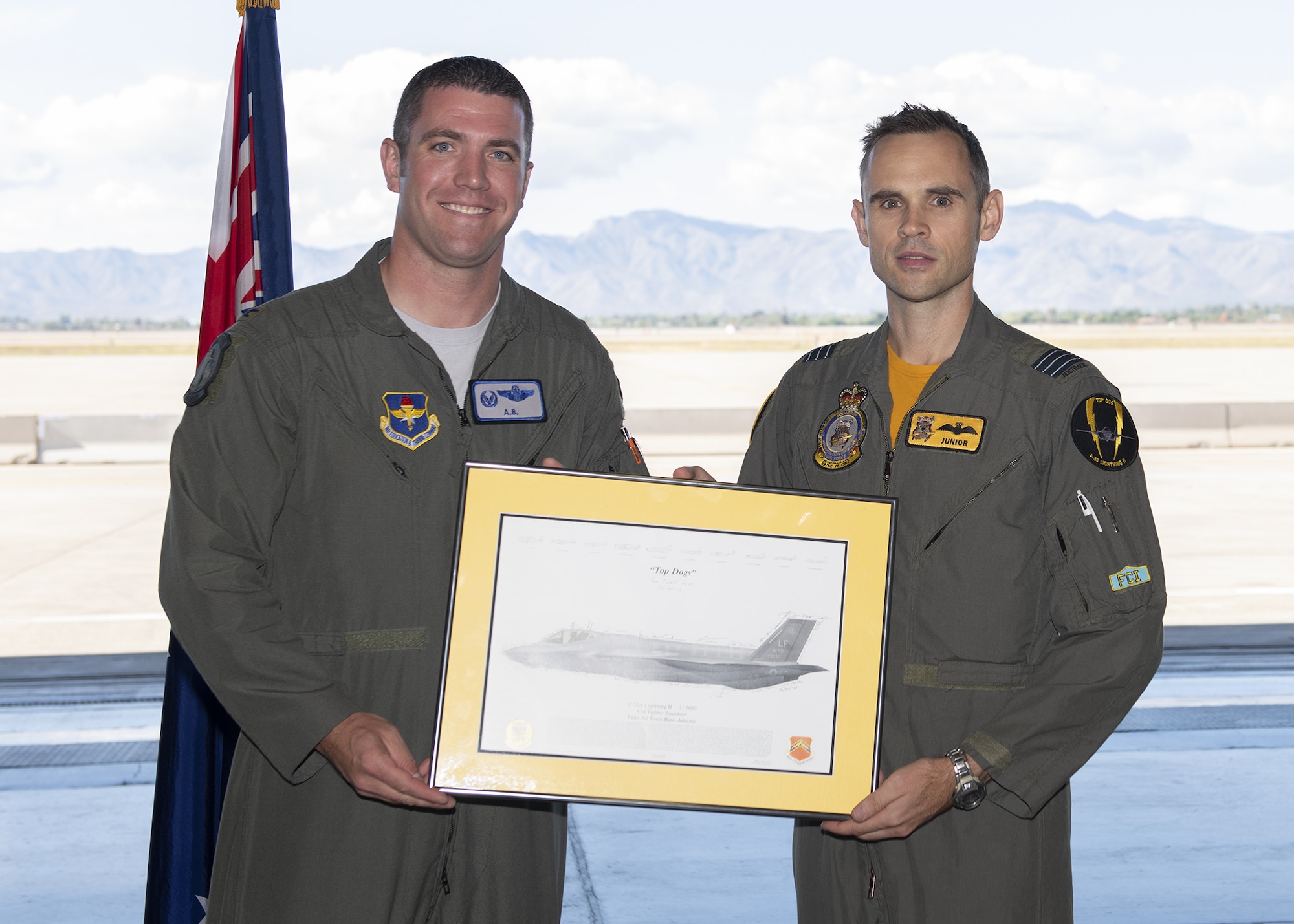 Col. Matthew Renbarger, 56th Operations Group commander (left), presents Lt. Col. Jordon Sander, 61st Fighter Squadron Australian Senior National Representative and new commander of Royal Australian Air Force No. 2 Operational Conversion Unit (No. 2 OCU), an F-35A lithograph during the RAAF Mateship ceremony Nov. 22, 2019, at Luke Air Force Base, Ariz