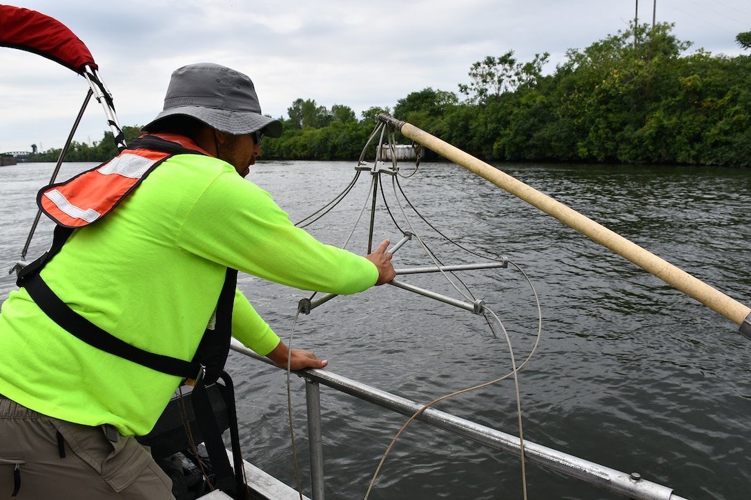 John Belcik, fish biologist and planner, guides a boom arm that will distribute electricity into the water, Aug. 16, 2019.