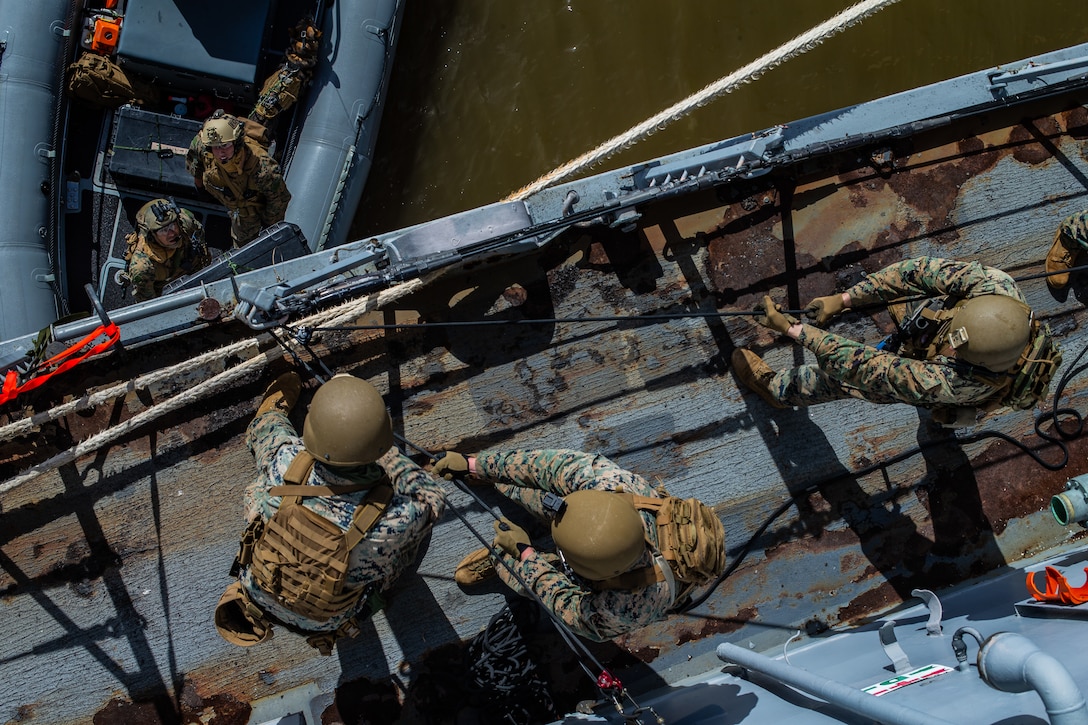 Marines hoist gear onto a simulated target vessel during Visit, Board, Search and Seizure training in Pearl Harbor, Hawaii, Jan. 10.
