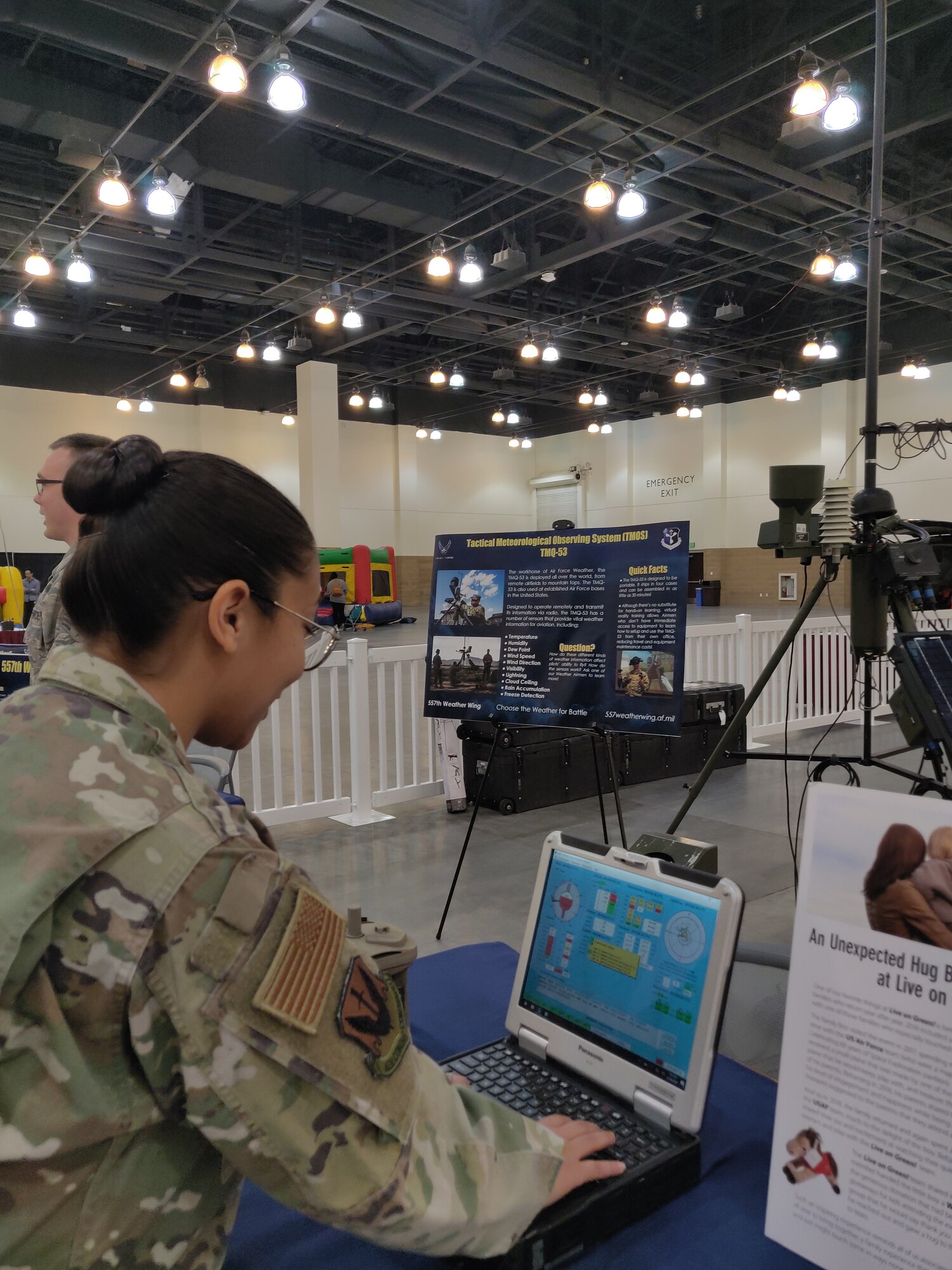 Airman working on laptop next to weather station.