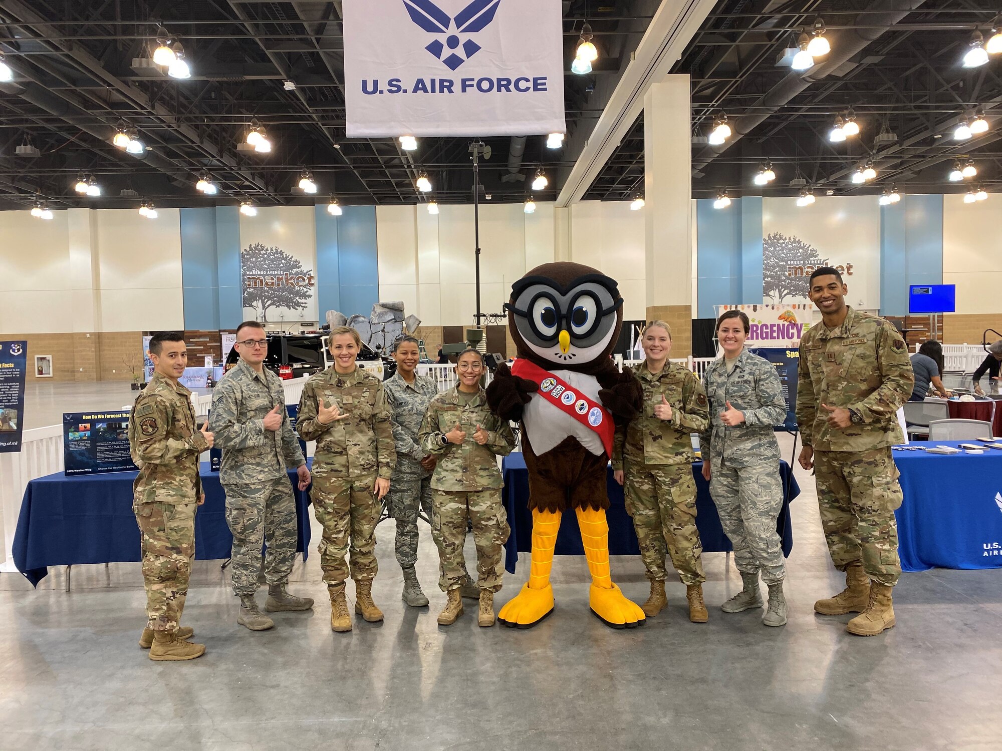 Airmen posing with mascot for group photo.