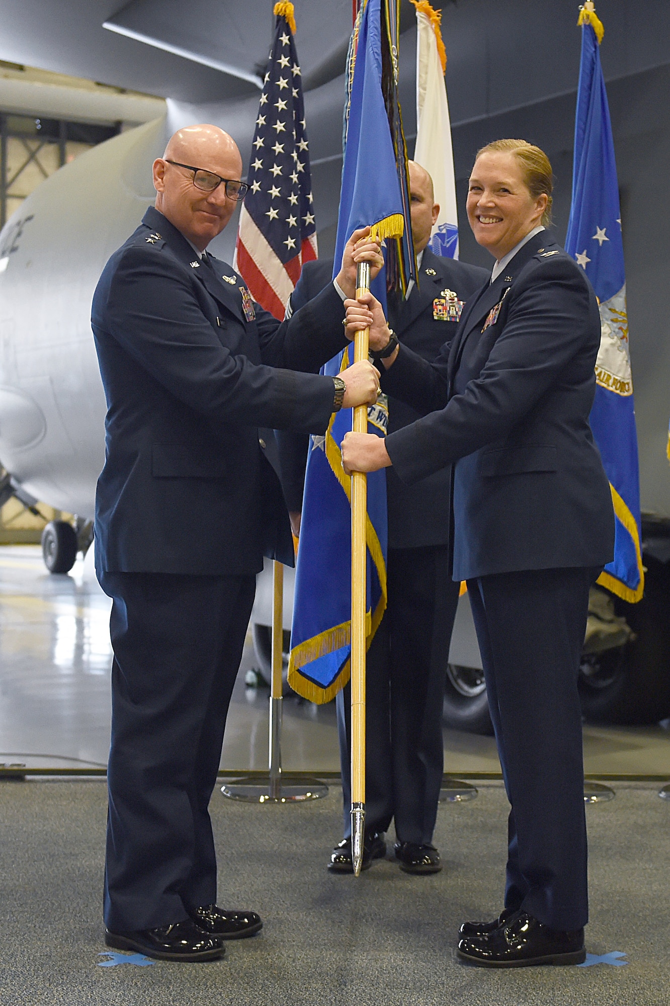 Maj. Gen. Sam Barrett, 18th Air Force commander, hands off the guidon to Col. Erin Staine-Pyne, 62nd Airlift Wing commander, on Joint Base Lewis-McChord, Wash., Jan 10, 2020.