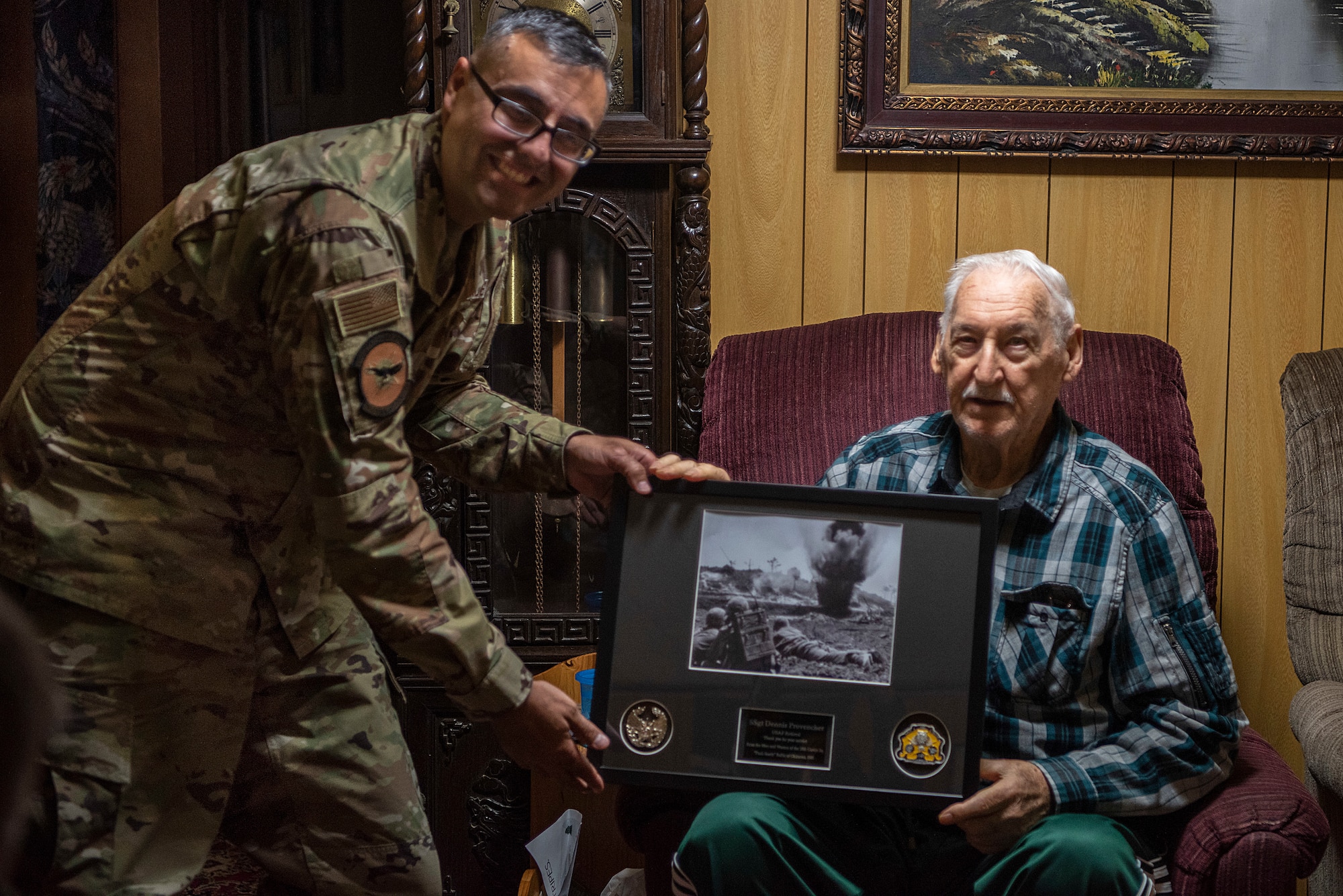 Retired U.S. Air Force Staff Sergeant Dennis Provencher, airborne and ground radio operator, right, talks with a group of Airmen including Lt. Col. Daniel Waid, 18th Communications Squadron commander, left, about how much has changed since Provencher initially joined in 1951 on Dec. 23, 2019, in Okinawa City, Okinawa. Provencher is a Guinness Book of World Records holder for most amount of blood donated. (U.S. Air Force Photo by Airman 1st Class Rebeckah Medeiros)