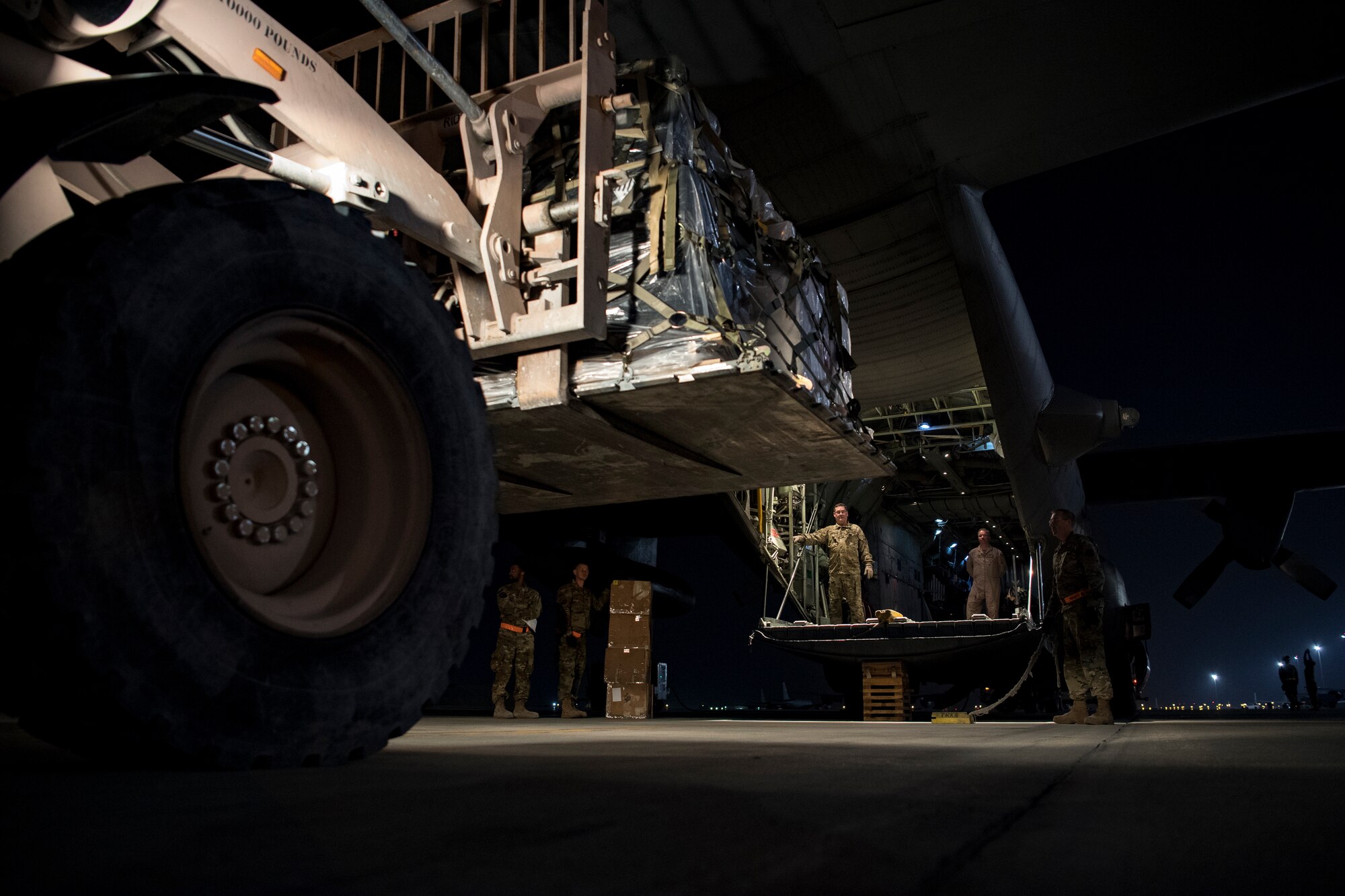 U.S. Air Force aircrew members assigned to the 746th Expeditionary Airlift Squadron direct the loading of cargo into a C-130 Hercules in the U.S. Central Command area of responsibility, Jan. 8, 2020.