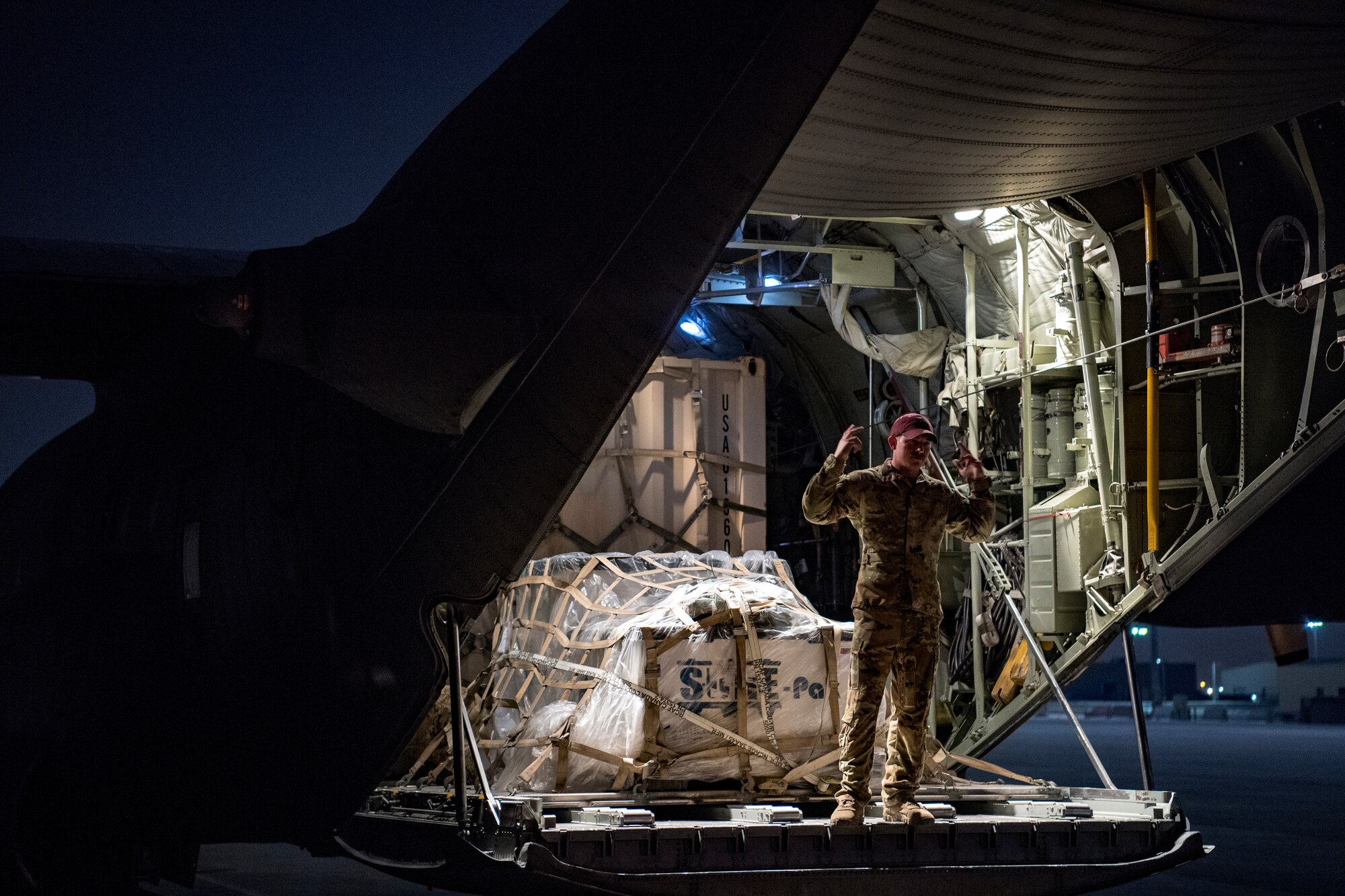 A U.S. Air Force loadmaster assigned to the 746th Expeditionary Airlift Squadron directs the loading of cargo into a C-130 Hercules in the U.S. Central Command area of responsibility, Jan. 8, 2020.