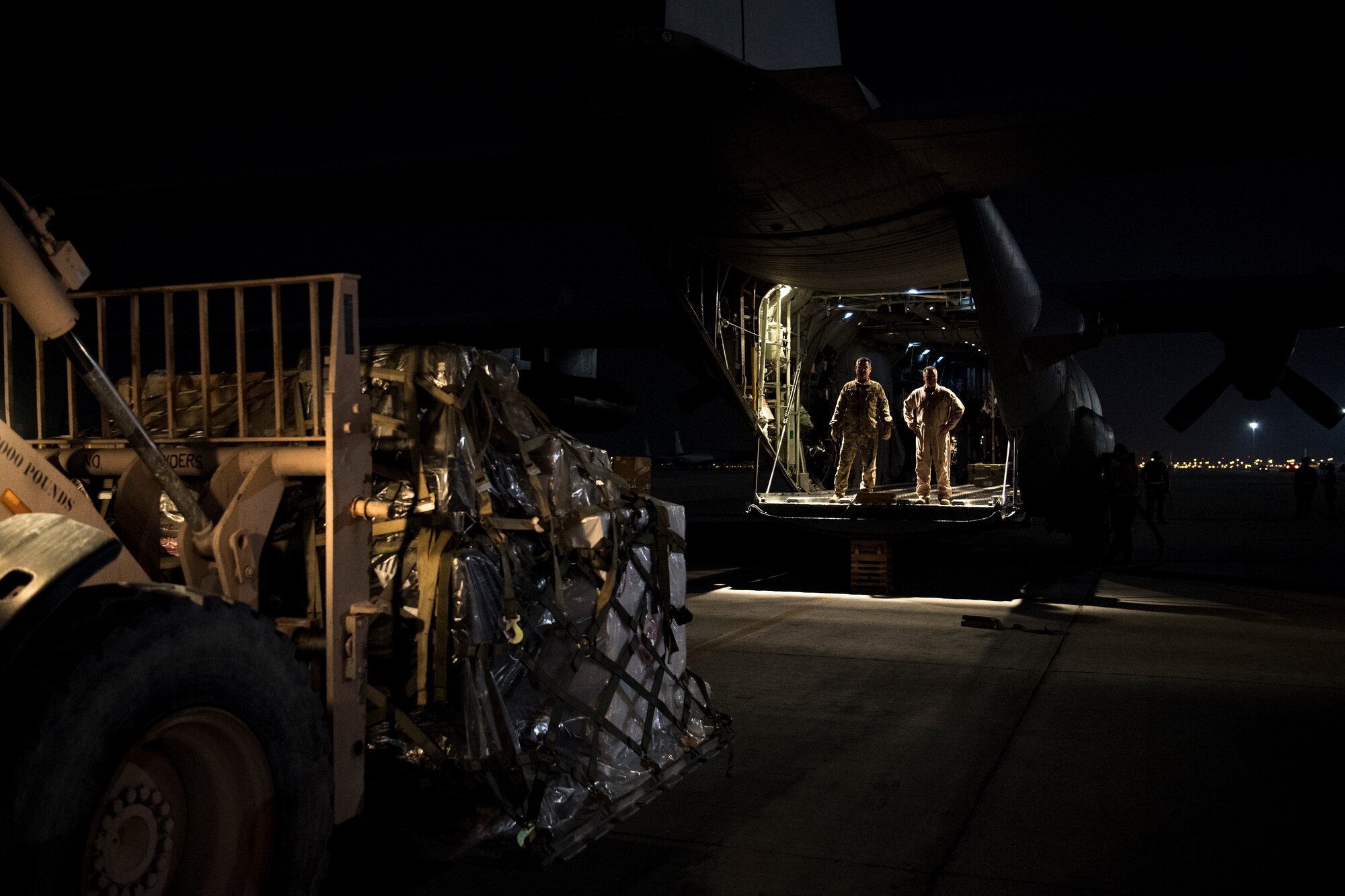 U.S. Air Force aircrew members assigned to the 746th Expeditionary Airlift Squadron direct the loading of cargo into a C-130 Hercules in the U.S. Central Command area of responsibility, Jan. 8, 2020.