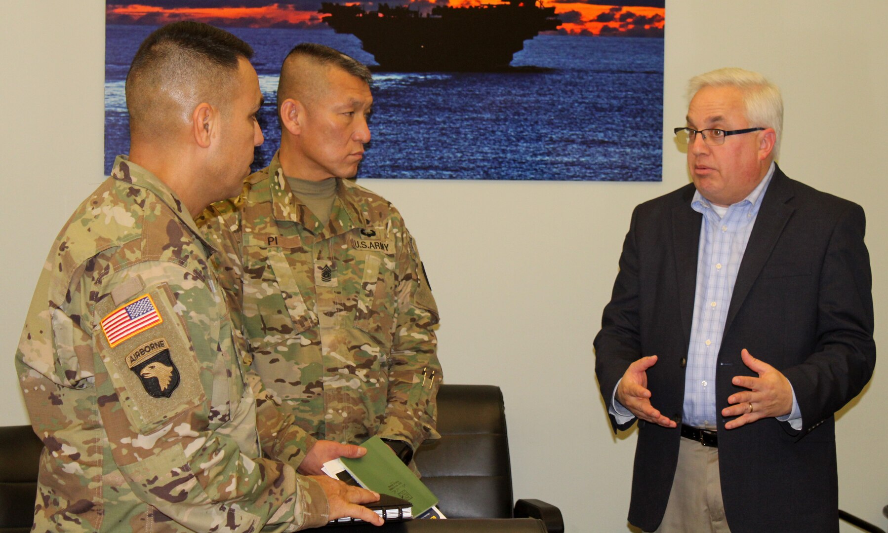 Army Sgt. Majs. Marco Torres, left, and Fu Pi, center, listen as DLA Troop Support Industrial Hardware Director of Supplier Operations Gary Shifton explains IH’s role in tracking Army ground forces readiness drivers Jan. 10, 2020, in Philadelphia.