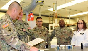 Army Sgt. Maj. Fu Pi, far left, reviews the Army regulation governing uniform guidance after being educated on the effects of “optical brighteners” in detergents and how they affect visibility of uniforms in the field Jan. 10, 2020, in Philadelphia.