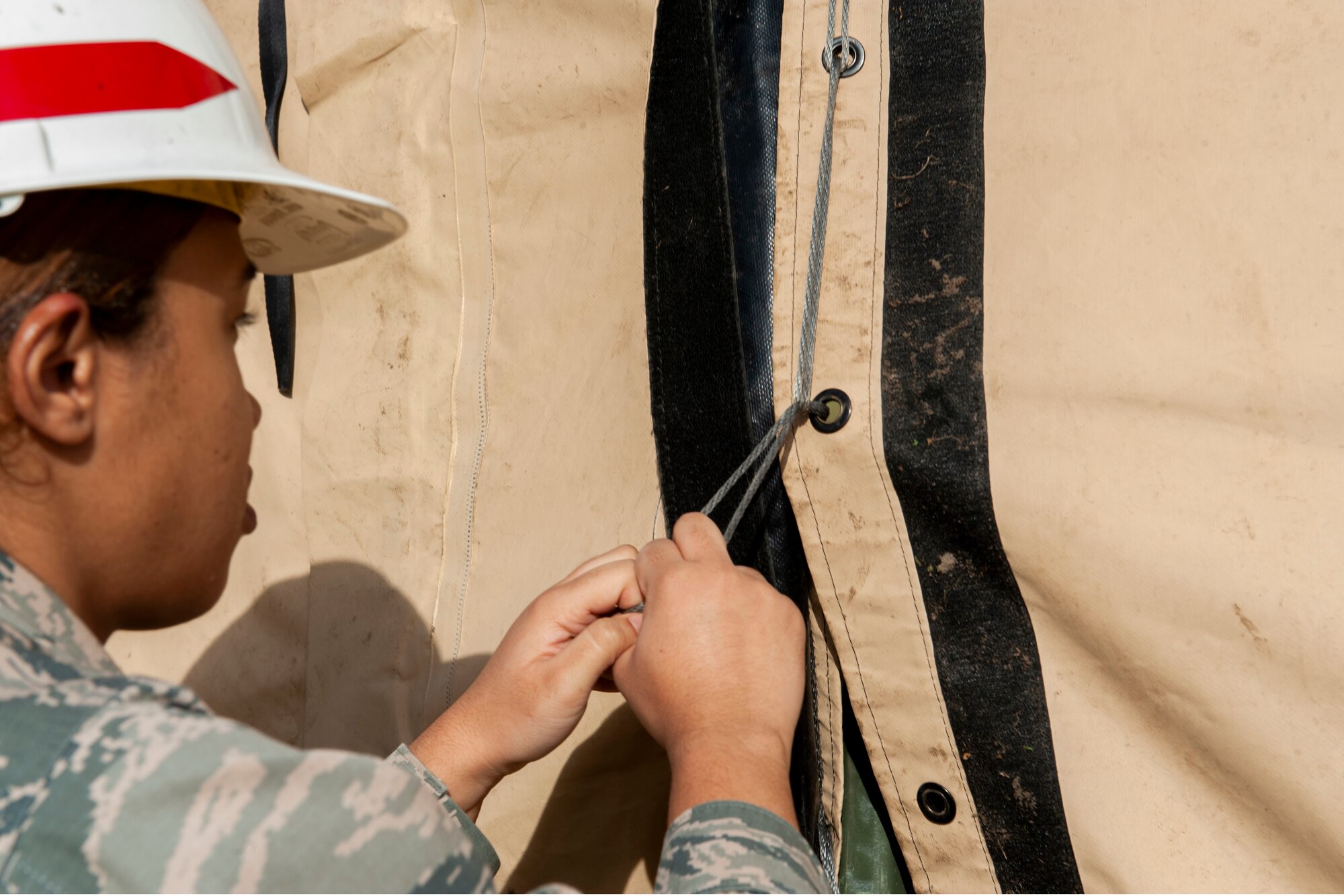 Photo of an Airman weaving cargo straps