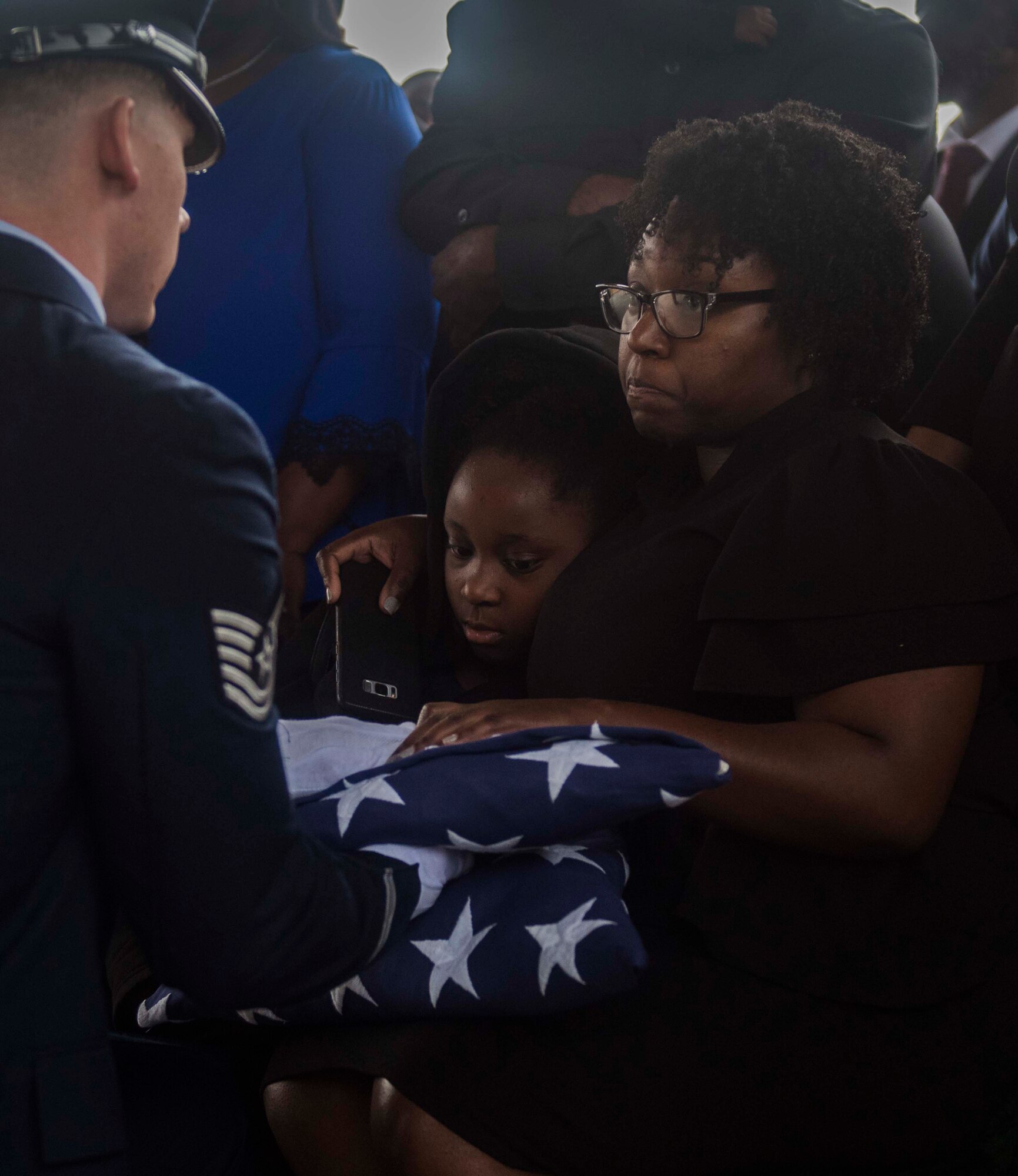 Tech. Sgt. Joseph Massoglia, Columbus Air Force Base Honor Guardsman, presents an American flag to LaTonya Bradley, wife of Staff Sgt. McNichols, and their daughter, LaRiah, at the Mississippi Veterans Memorial Cemetery on Jan. 13, 2020, in Newton County, Miss. McNichols was a member of the 855th Aircraft Maintenance Squadron at Nellis Air Force Base, Nev., prior to his death. (U.S. Air Force photo by Airman Davis Donaldson)
