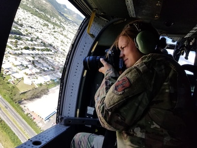 U.S. Air Force Master Sgt. Caycee Watson, public affairs superintendent with the 156th Wing, Puerto Rico Air National Guard, documents base camp “tent cities” from a UH-60 Black Hawk helicopter, Jan. 15, 2020. Guard members helped set up the emergency shelters for victims of earthquakes that struck Puerto Rico in December 2019 and January 2020.