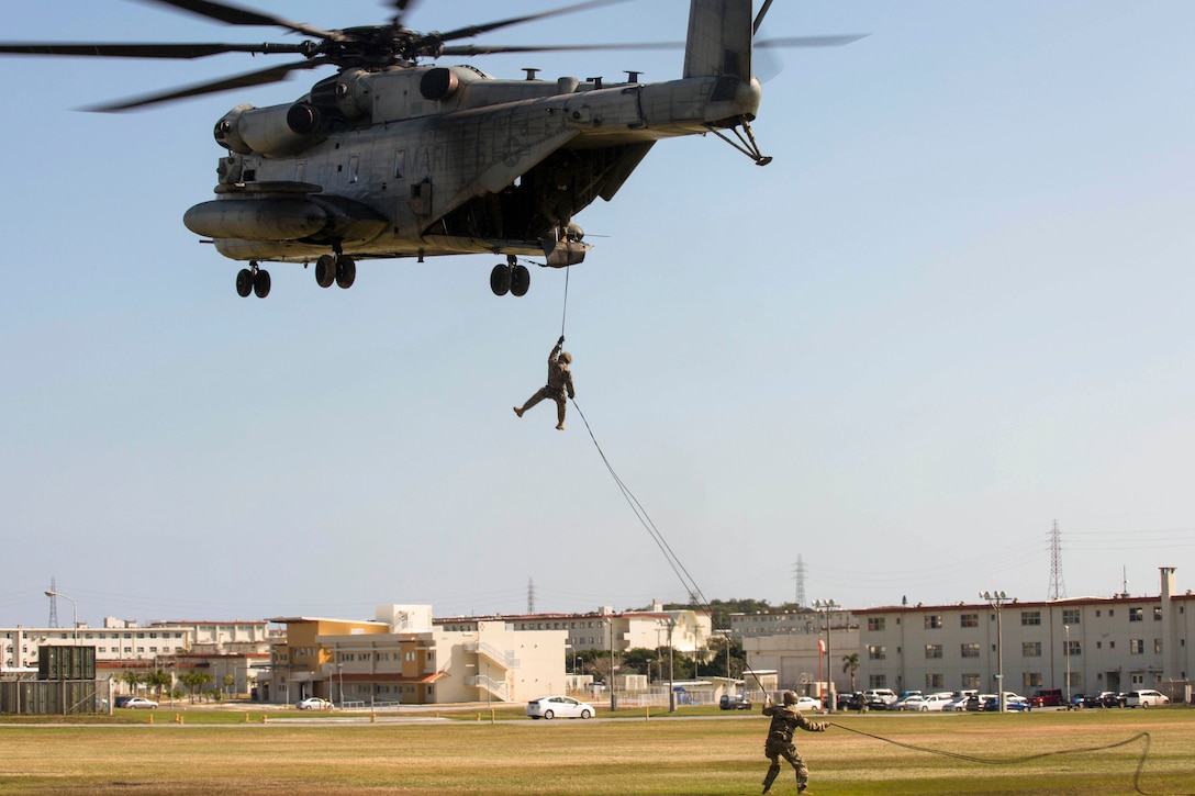 A Marine rappels from a helicopter.