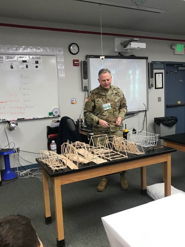 TAM Commander COL Philip Secrist at the start of the testing phase of the bridge build activity, looking over the various submissions.