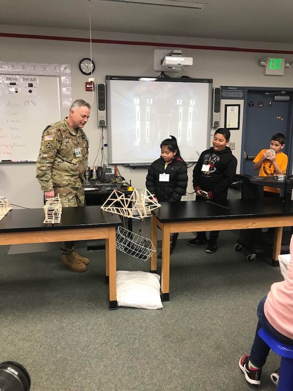 TAM Commander COL Philip Secrist leads the students in the weight bearing tests for each team's bridge, as one team's fails on camera.