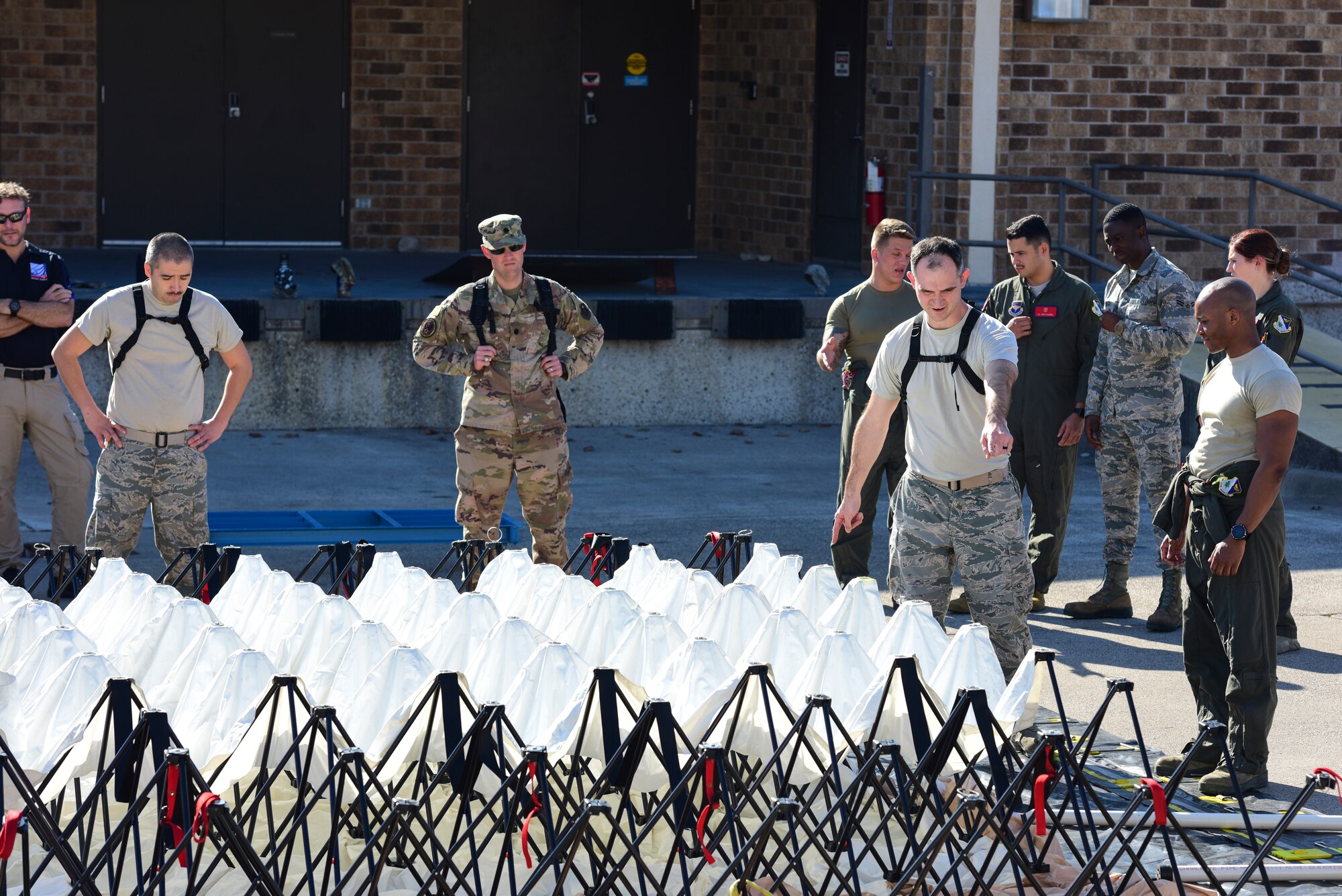 Airmen from the 47th Medical Group at Laughlin Air Force Base, Texas, plan the set-up of their in-place patient decontamination tent on Jan. 14, 2020, as part of the practice phase of exercise Ready Eagle. The exercise is intended to provide training for the home station medical response in case of a chemical, biological, radiological or nuclear mass casualty. (U.S. Air Force photo by Senior Airman Anne McCready)