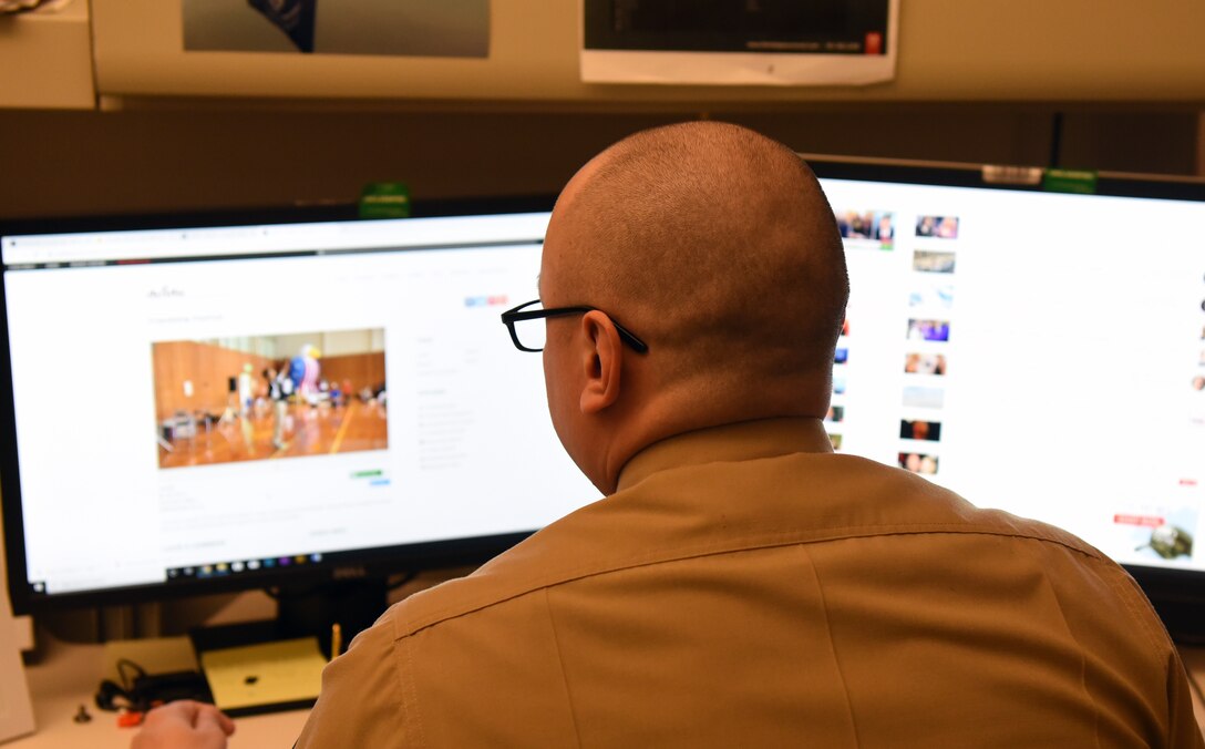 A man looks at computer screens.