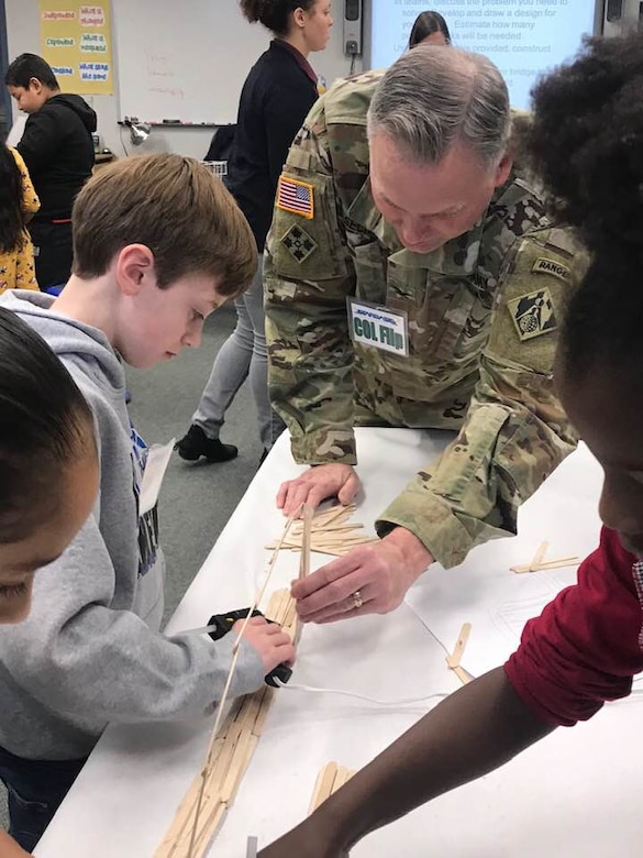 USACE Middle East District Commander COL Philip Secrist assist members of Team echo during the bridge build competition at STARBASE Academy, in Winchester, Va., by pointing out comparative strengths of various shapes.