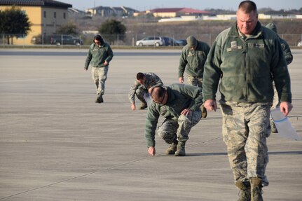 433rd Airlift Wing members perform a “FOD walk” to clean foreign objects and debris from the flightline Jan. 12, 2019 at Joint Base San Antonio-Lackland, Texas.