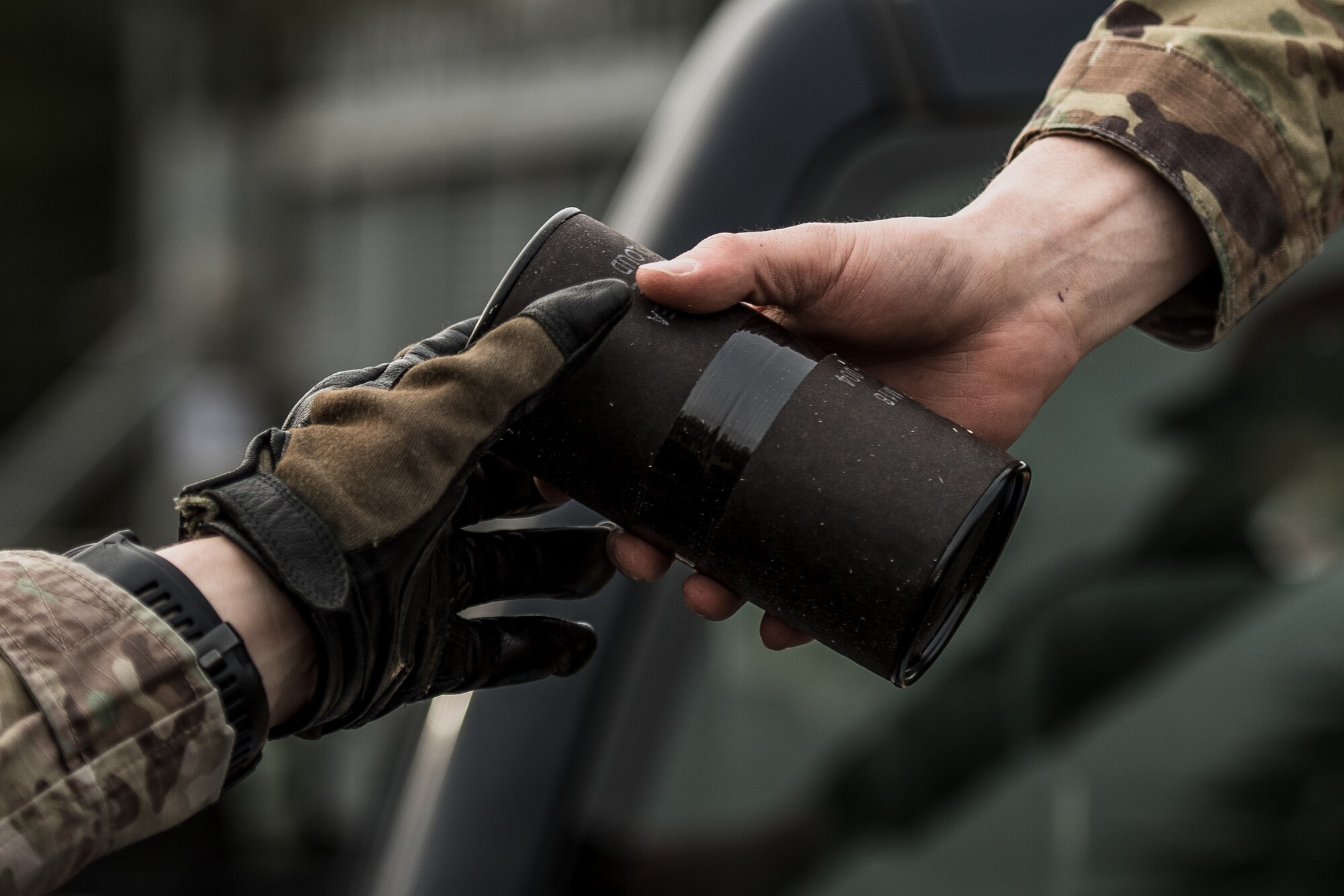 A U.S. Air Force combat arms instructor assigned to the 435th Security Forces Squadron, right, hands a smoke grenade to a Defender in preparation for exercise Frozen Defender in Grostenquin, France, Jan. 14, 2020. Frozen Defender tests the squadron’s capabilities in a contested environment under harsh conditions. To provide realism to the exercise, the squadron utilized blank rounds and smoke grenades. (U.S. Air Force photo by Staff Sgt. Devin Boyer)