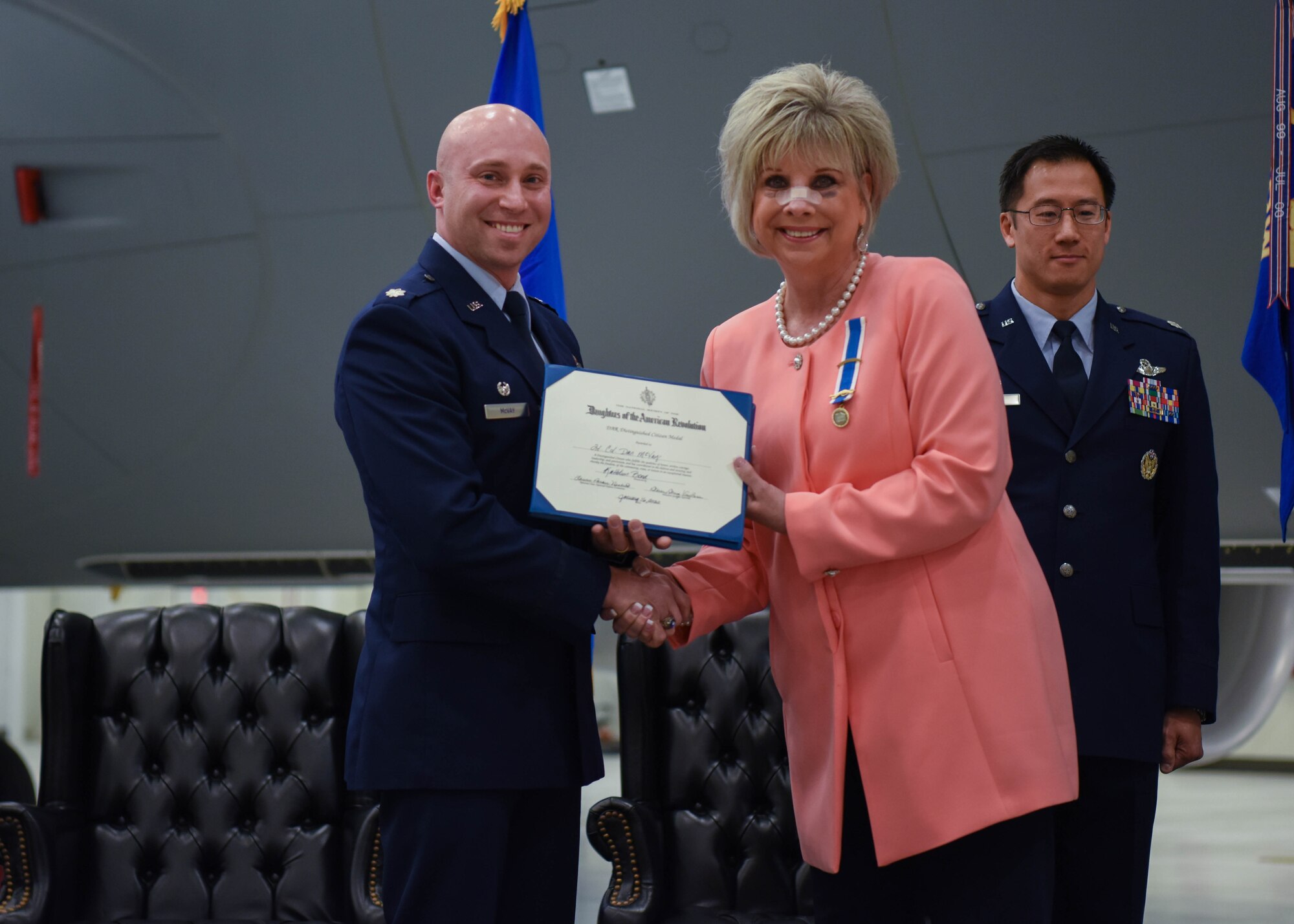 Kathy Bond, 22nd Air Refueling Wing honorary commander, presents the Daughters of the American Revolution Distinguished Citizen Medal citation to Lt. Col. Daniel McVay, the outgoing 22nd Operations Support Squadron commander, during a change of command ceremony Jan. 16, 2020, at McConnell Air Force Base, Kansas. The DAR Distinguished Citizen Medal is presented to an individual who fulfills the qualities of honor, service, courage, leadership and patriotism. The medal was established to recognize worthy citizens for extraordinary service. (U.S. Air Force photo by Airman 1st Class Marc A. Garcia)