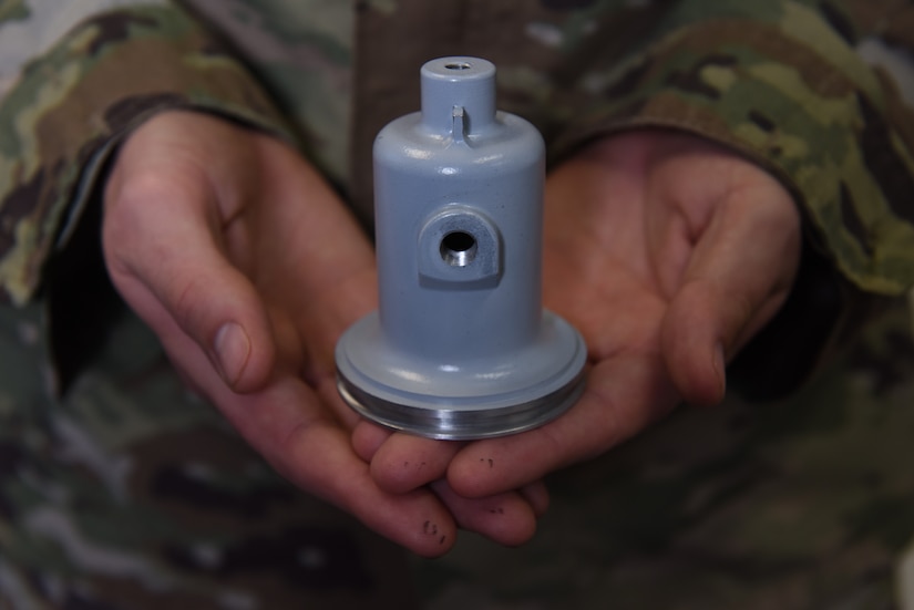 Capt. David Sage, 628th Logistics Readiness Squadron vehicle management flight commander, holds a 3D-printed fuel truck cap valve for an R-11 Refueler truck Jan. 14, 2020, at Joint Base Charleston, SC.