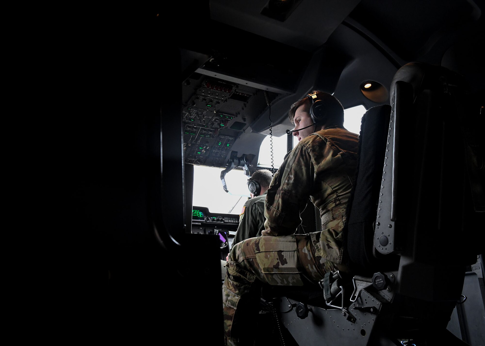 An Airman sits on the flight-deck of a C-130