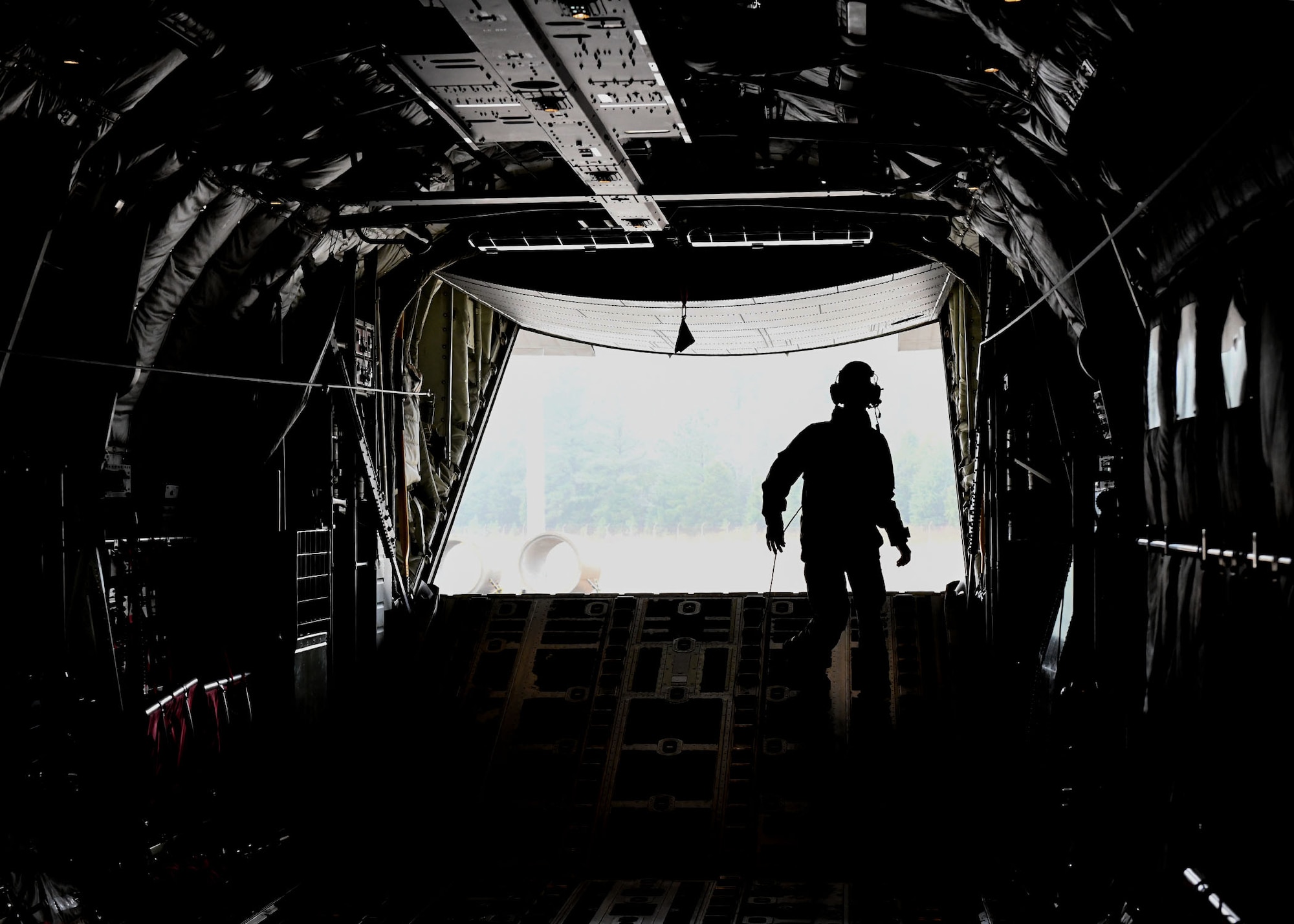 An Airman stands in the back of a C-130.