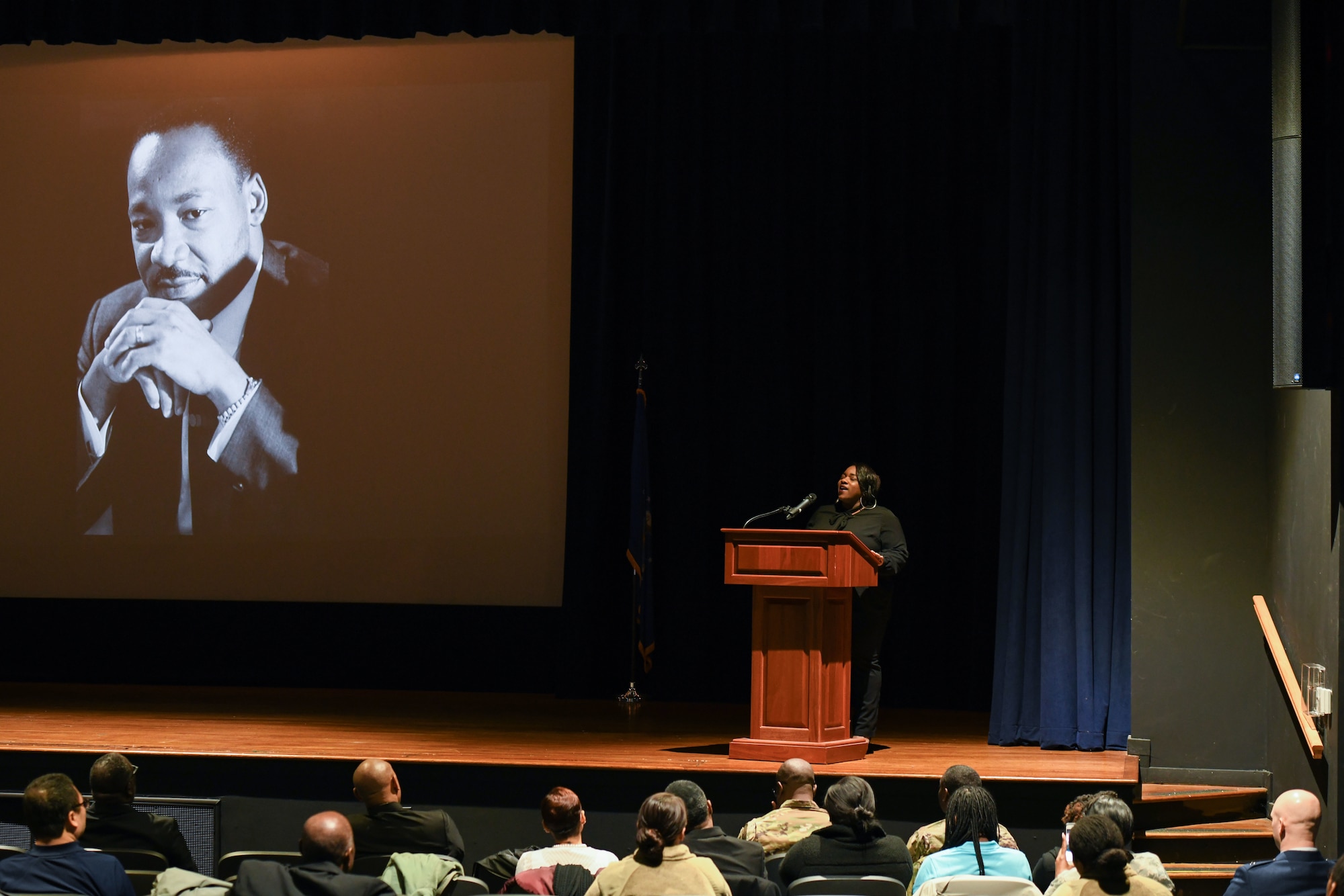 A lady sings a song at a podium
