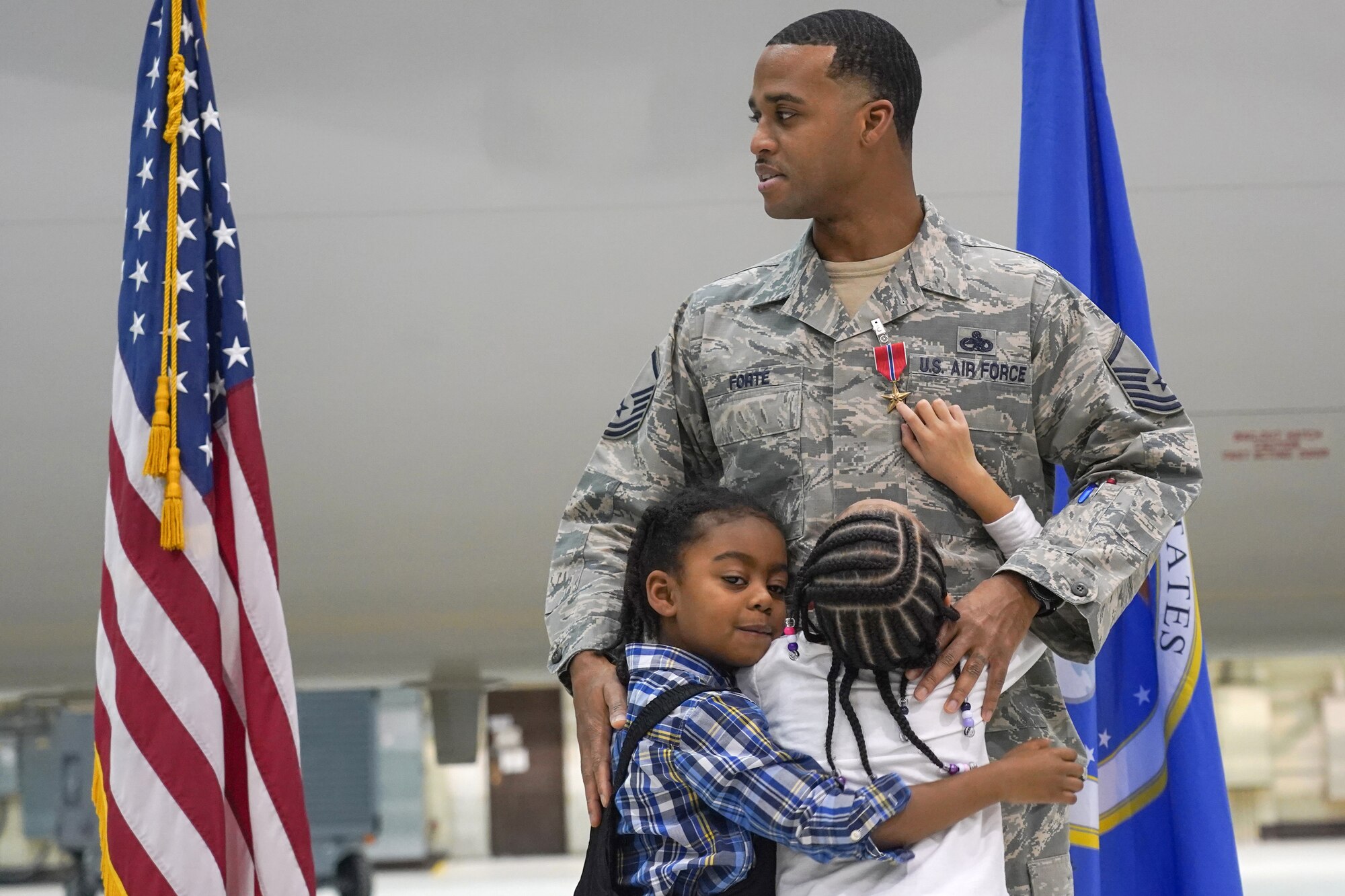 Master Sgt. and his children during a ceremony awarding him the Bronze Star Medal