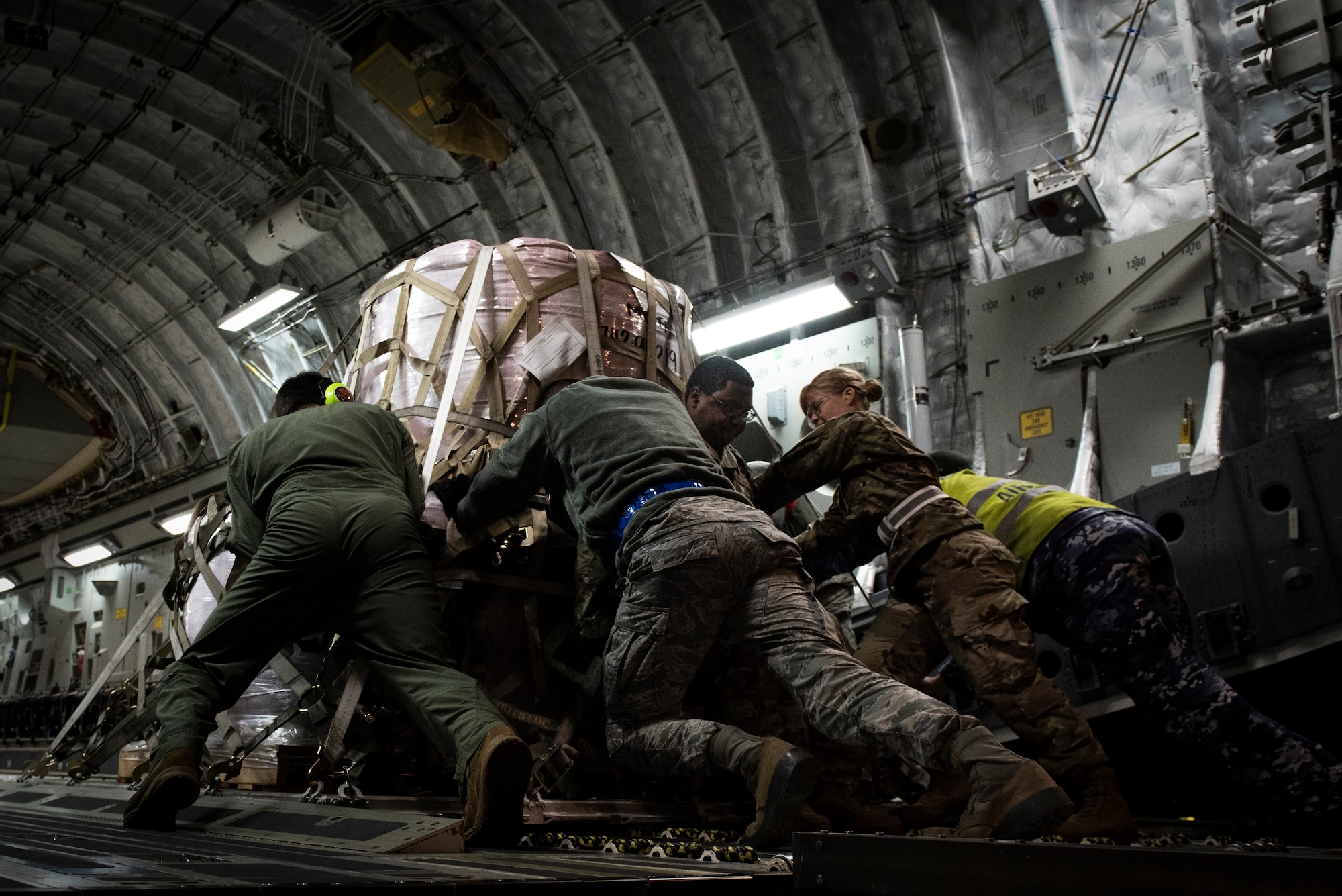 Airmen and RAAF Airmen push fire suppressant on to aircraft.