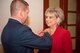 Col. Mark Baran, 22nd Air Refueling Wing vice commander, pins a commander badge on Kathy Bond, 22nd ARW honorary commander, at the honorary commander assumption of command Dec. 4, 2019, at McConnell Air Force Base, Kansas. Bond was previously the honorary commander of the 22nd Operation Support Squadron before moving up to the wing level. (U.S. Air Force photo by Staff Sergeant Chris Thornbury)