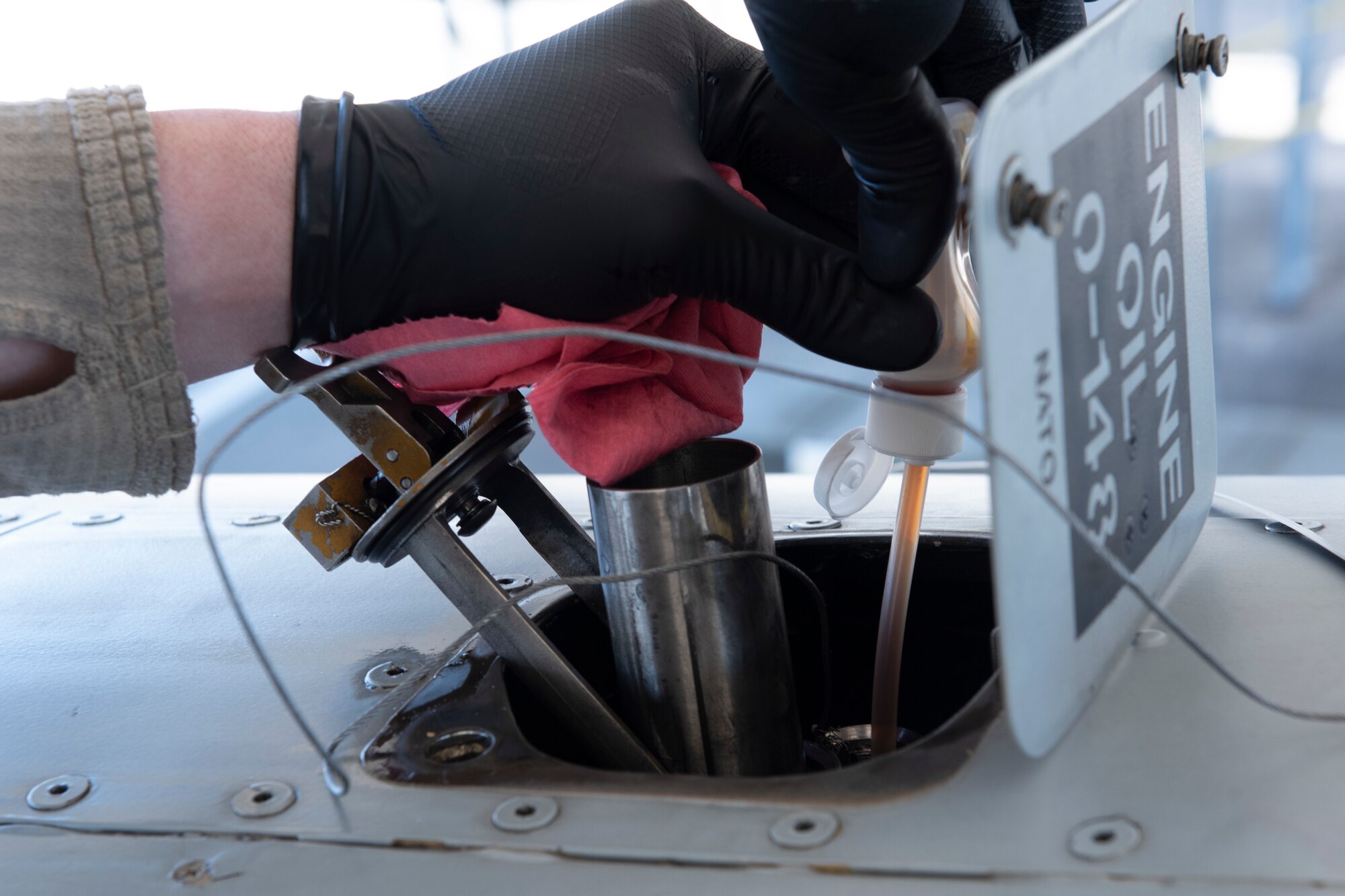 A photo of an Airman extracting oil from an A-10C Thunderbolt II during a joint oil analysis.