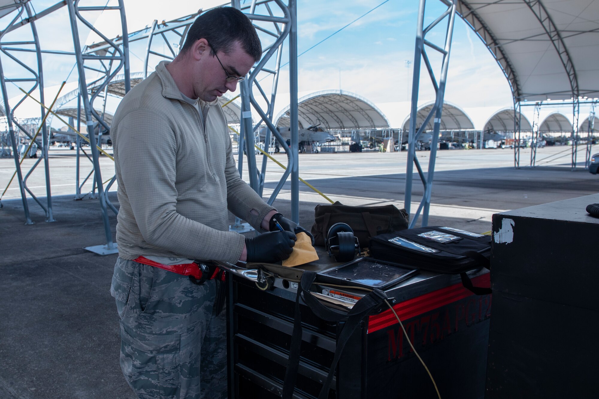 A photo of an Airman packaging oil samples and a form 2026 during a joint oil analysis.