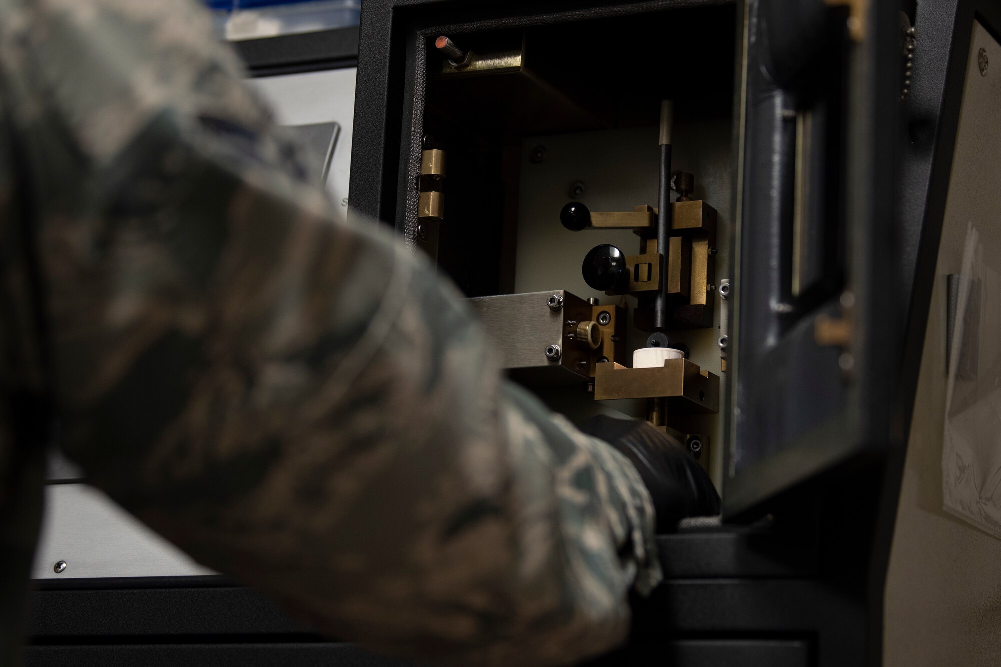 A photo of an airman preparing an oil sample for a spectrographic analysis.
